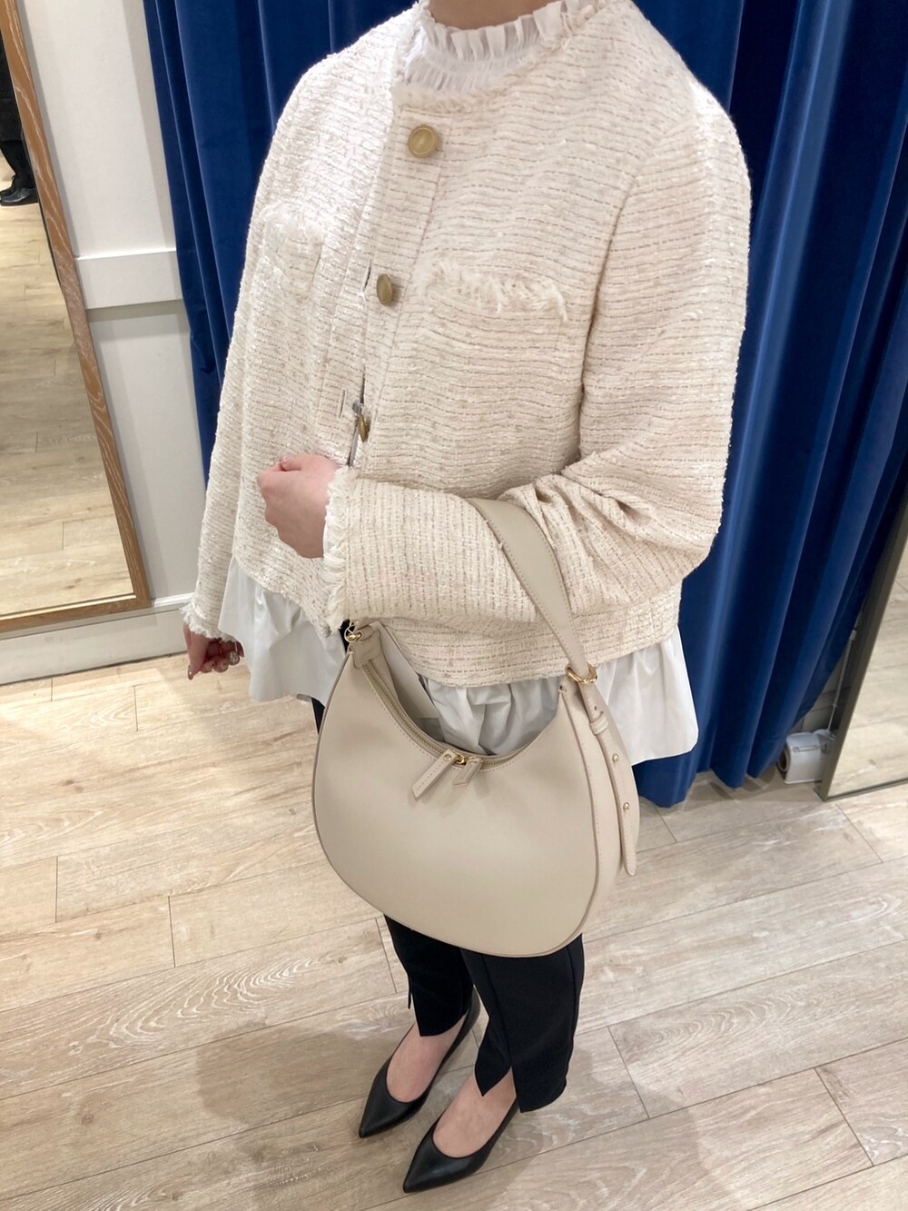 ホワイト系のノーカラージャケット、ホワイト系のシャツ/ブラウス、ホワイト系のショルダーバッグを着用したレディースの冬コーディネートの3枚目の写真