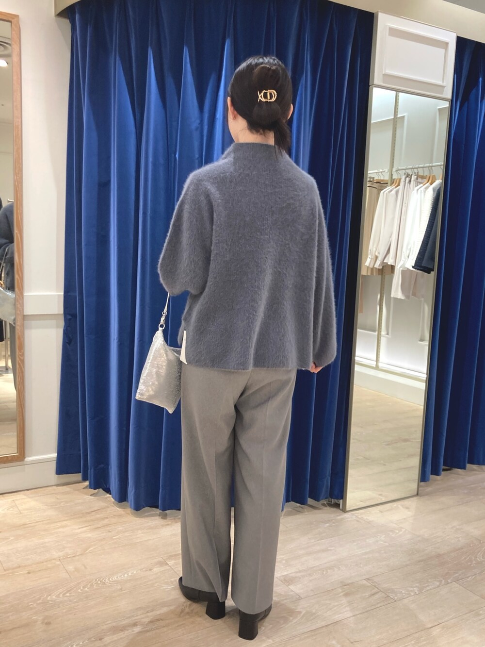 グレー系のニット/セーター、シルバー系のクラッチバッグ、グレー系のその他パンツを着用したレディースの冬コーディネートの3枚目の写真