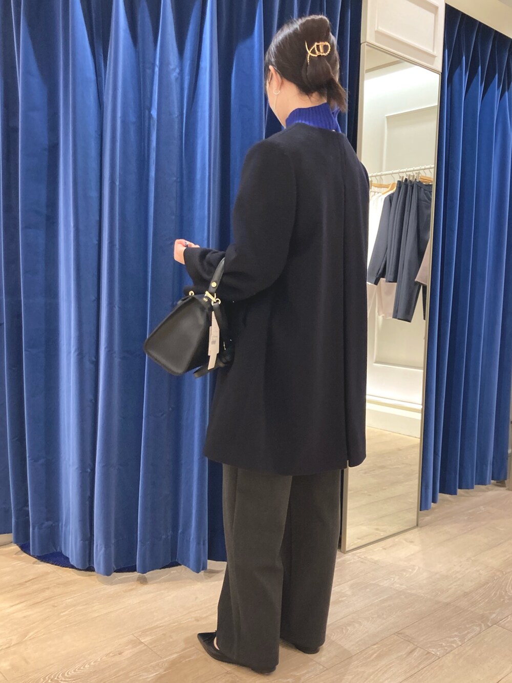 ブルー系のその他アウター、ブルー系のニット/セーター、ブラック系のパンプスを着用したレディースの冬コーディネートの3枚目の写真