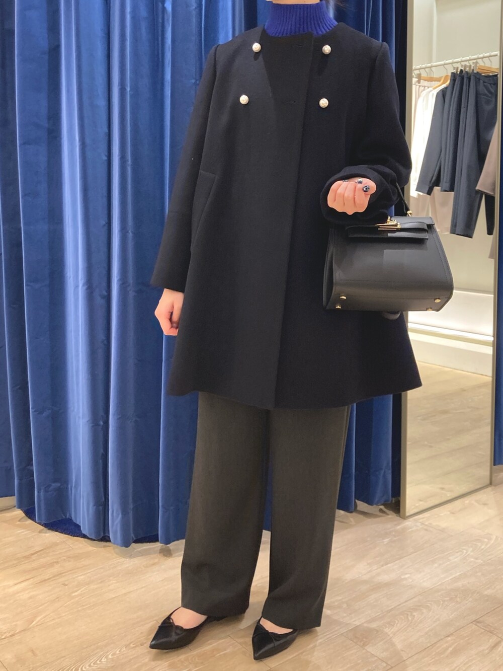 ブルー系のその他アウター、ブルー系のニット/セーター、ブラック系のパンプスを着用したレディースの冬コーディネートの2枚目の写真