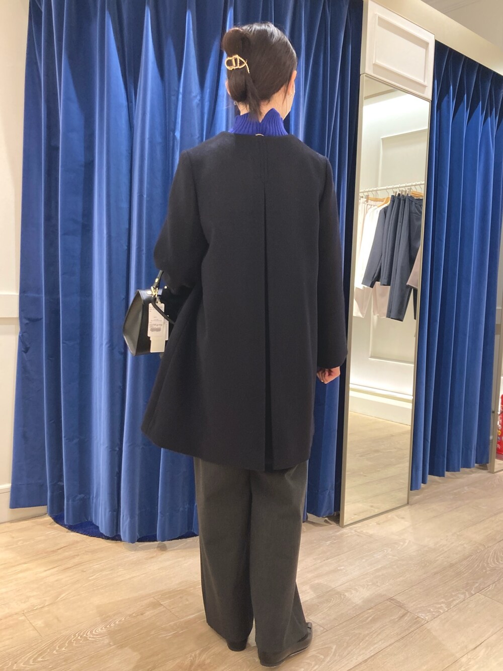 ブルー系のその他アウター、ブルー系のニット/セーター、ブラック系のパンプスを着用したレディースの冬コーディネートの4枚目の写真