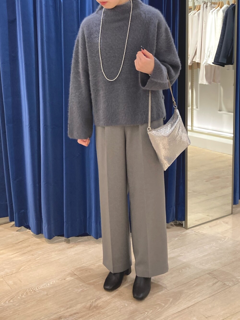 グレー系のニット/セーター、シルバー系のクラッチバッグ、グレー系のその他パンツを着用したレディースの冬コーディネートの2枚目の写真