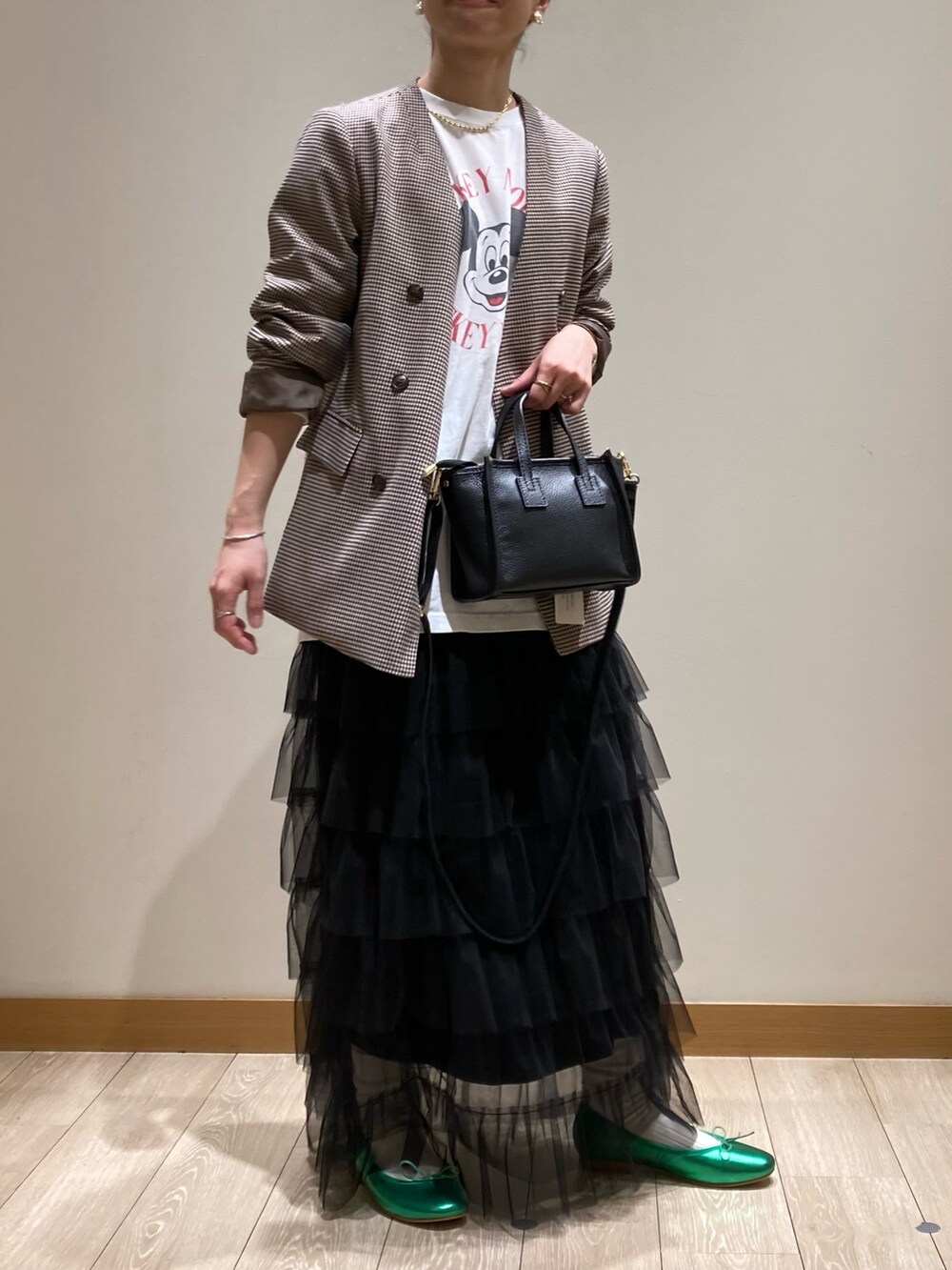 ブラック系のトートバッグ、ブラック系のスカート、グリーン系のバレエシューズを着用したレディースの春コーディネートの7枚目の写真