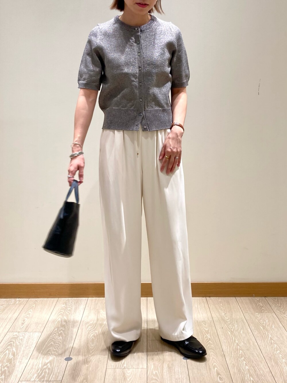 ホワイト系のその他パンツ、ブラック系のショルダーバッグ、グレー系のニット/セーターを着用したレディースの秋コーディネートの5枚目の写真