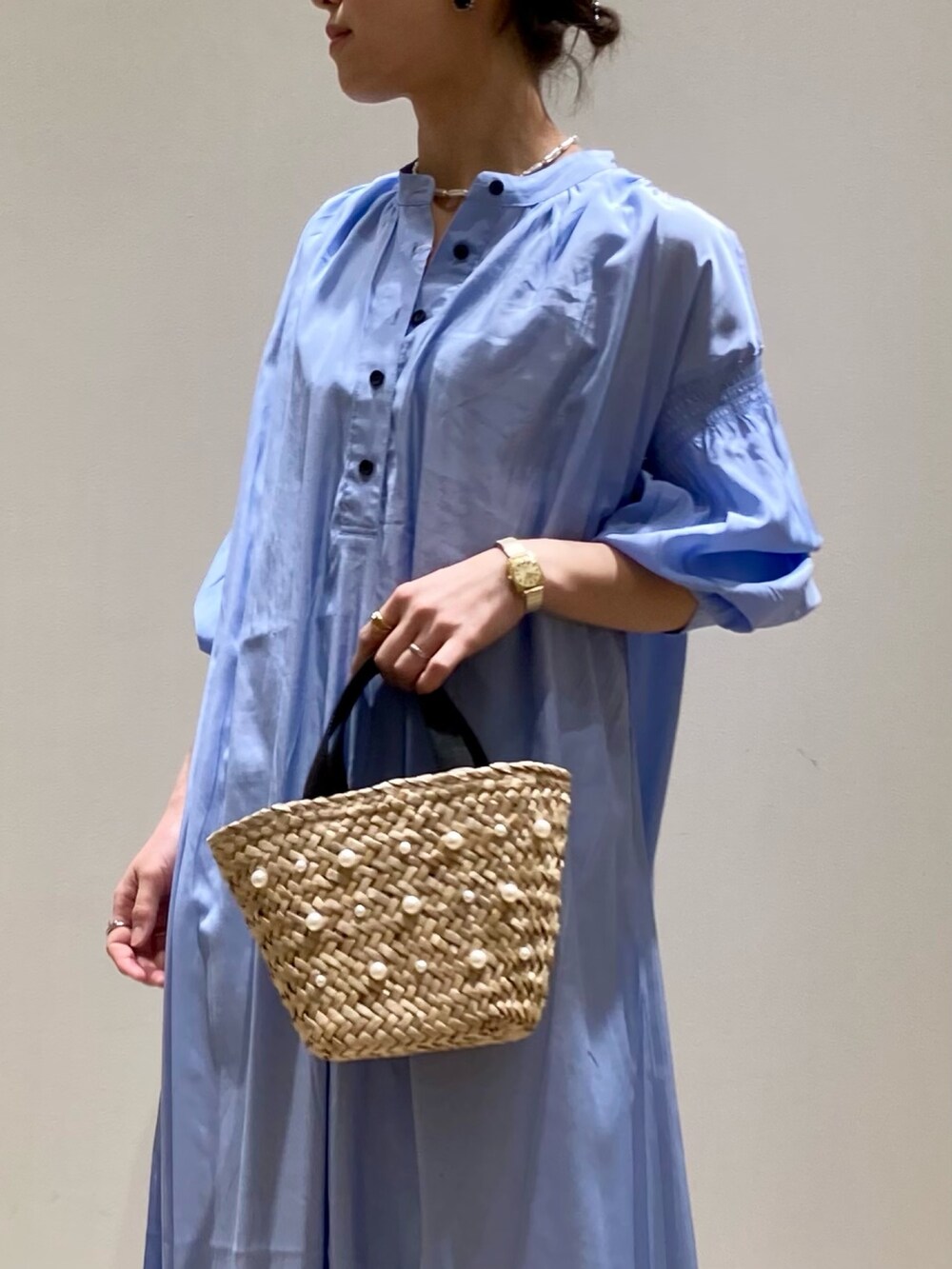 ブルー系のワンピース、ホワイト系のトートバッグ、ゴールド系のネックレスを着用したレディースの春コーディネートの9枚目の写真