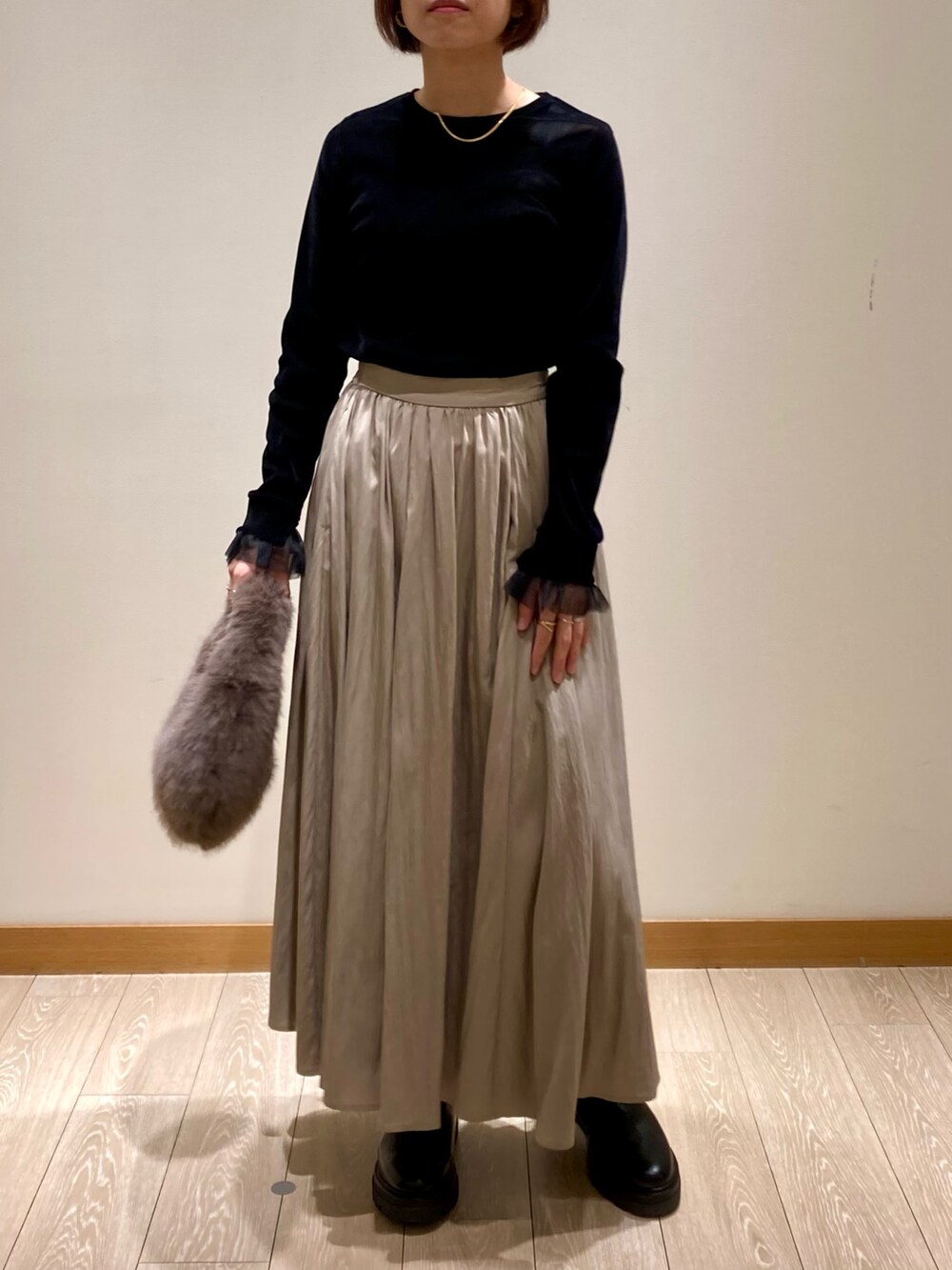 グレー系のハンドバッグ、ブラック系のブーツ、ブラック系のTシャツ/カットソーを着用したレディースの秋コーディネートの7枚目の写真