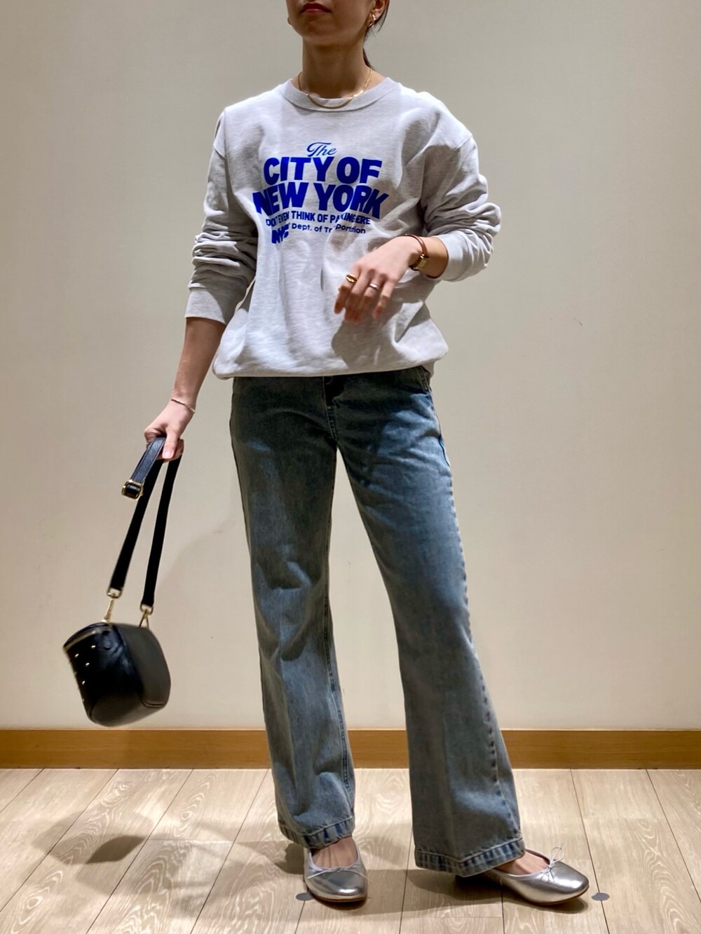 ブルー系のデニムパンツ、ブラック系のショルダーバッグ、シルバー系のバレエシューズを着用したレディースの冬コーディネートの2枚目の写真