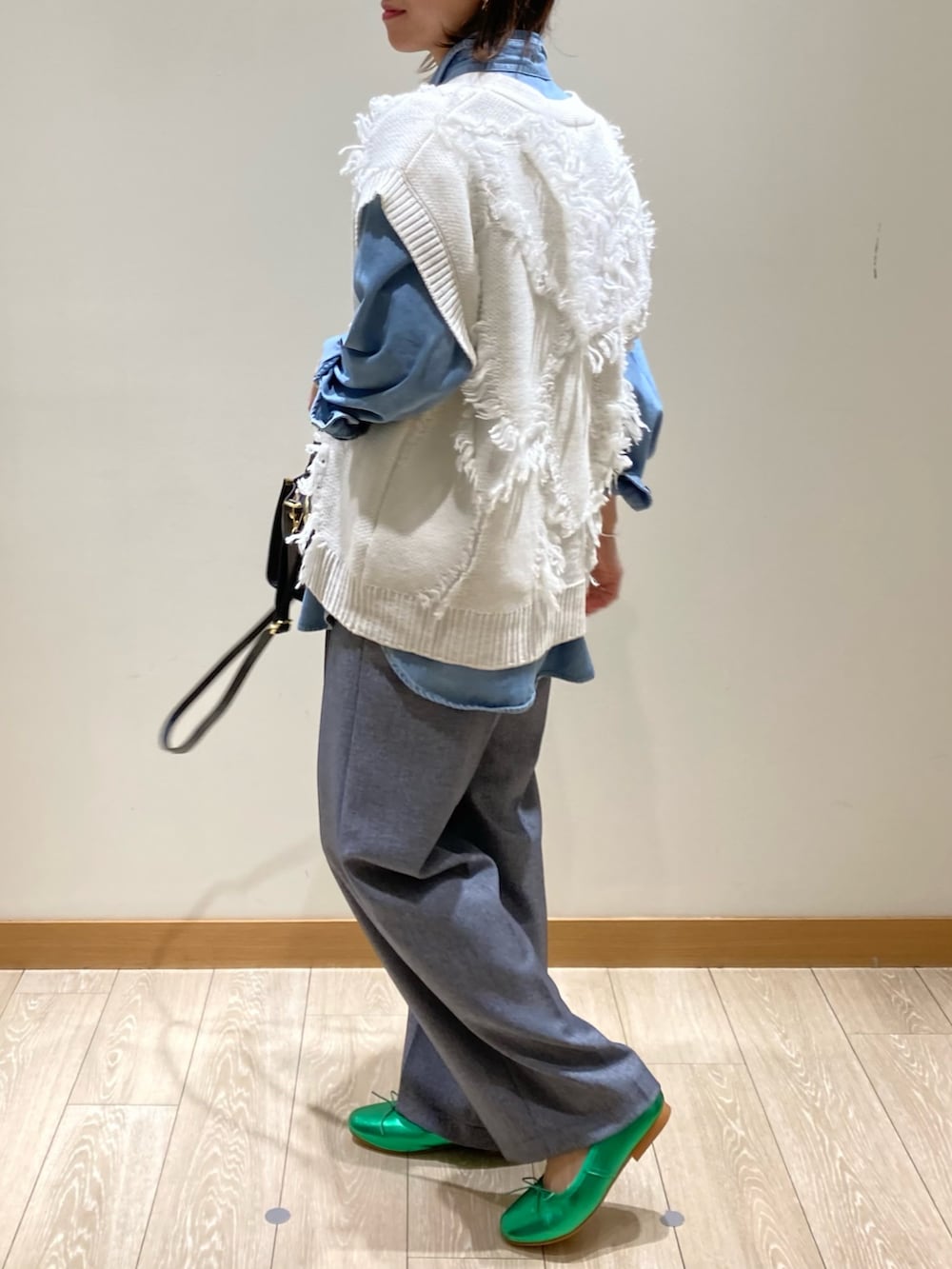 ブラック系のトートバッグ、ブルー系のスラックス、グリーン系のバレエシューズを着用したレディースの冬コーディネートの6枚目の写真