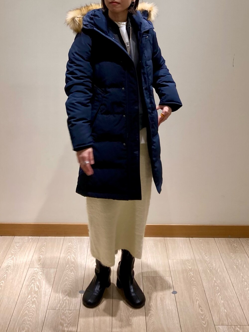 ブルー系のダウンジャケット/コート、ホワイト系のスカート、グレー系のスウェットを着用したレディースの冬コーディネートの2枚目の写真