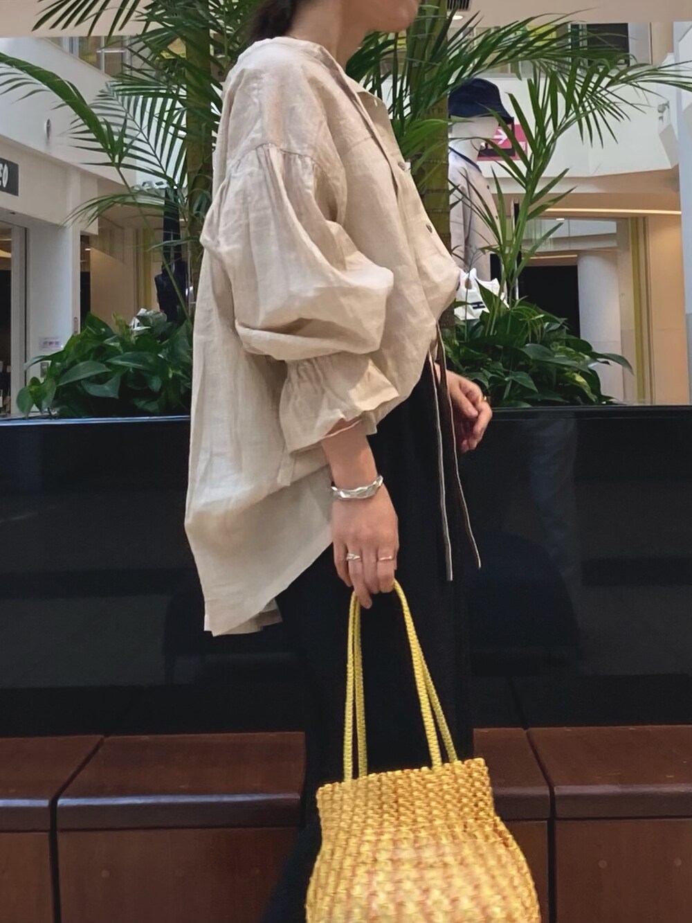 ブラック系のスカート、ベージュ系のシャツ/ブラウス、イエロー系のショルダーバッグを着用したレディースの春コーディネートの3枚目の写真