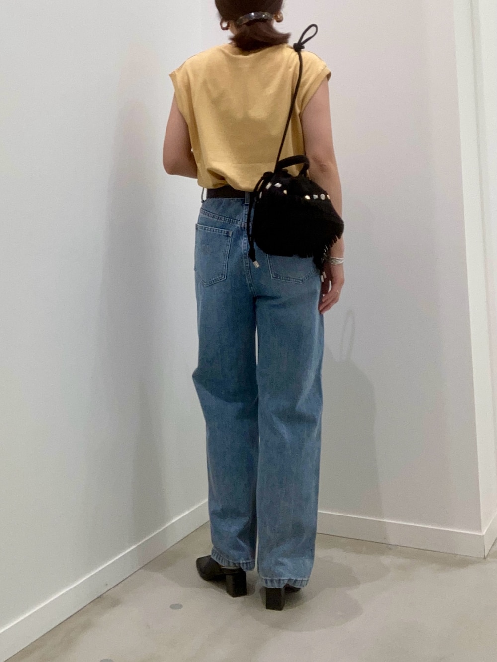 イエロー系のTシャツ/カットソー、ブルー系のデニムパンツ、ブラック系のショルダーバッグを着用したレディースの夏コーディネートの3枚目の写真