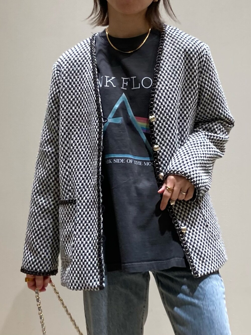 ブルー系のデニムパンツ、シルバー系のショルダーバッグ、ブラック系のノーカラージャケットを着用したレディースの冬コーディネートの7枚目の写真