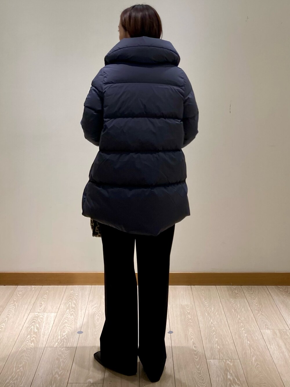 ブラック系のその他パンツ、グレー系のダウンジャケット/コート、イエロー系のニット/セーターを着用したレディースの冬コーディネートの6枚目の写真