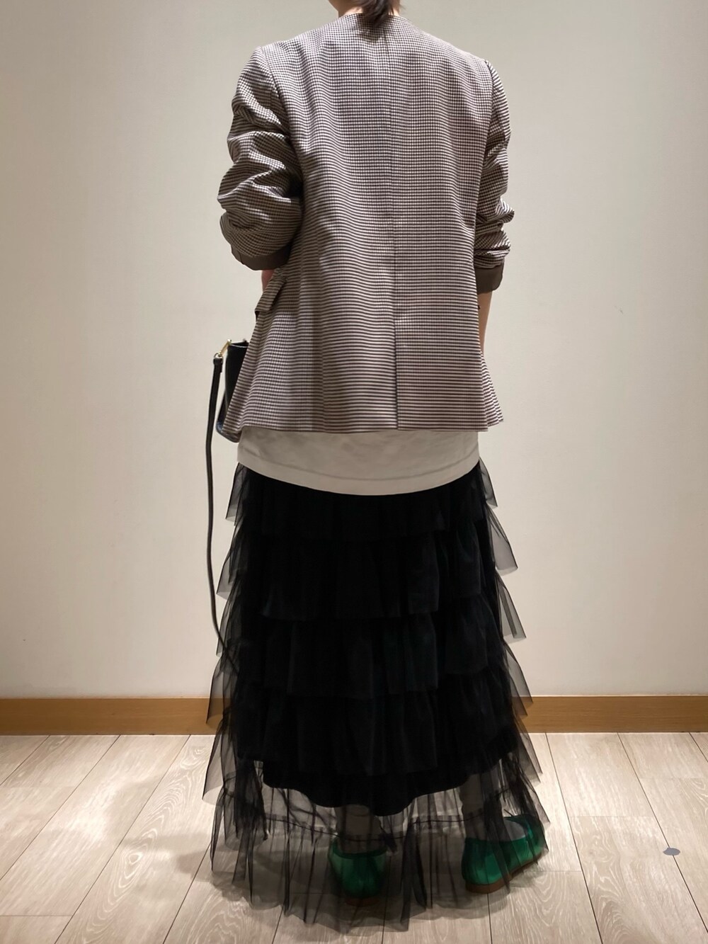 ブラック系のトートバッグ、ブラック系のスカート、グリーン系のバレエシューズを着用したレディースの春コーディネートの5枚目の写真