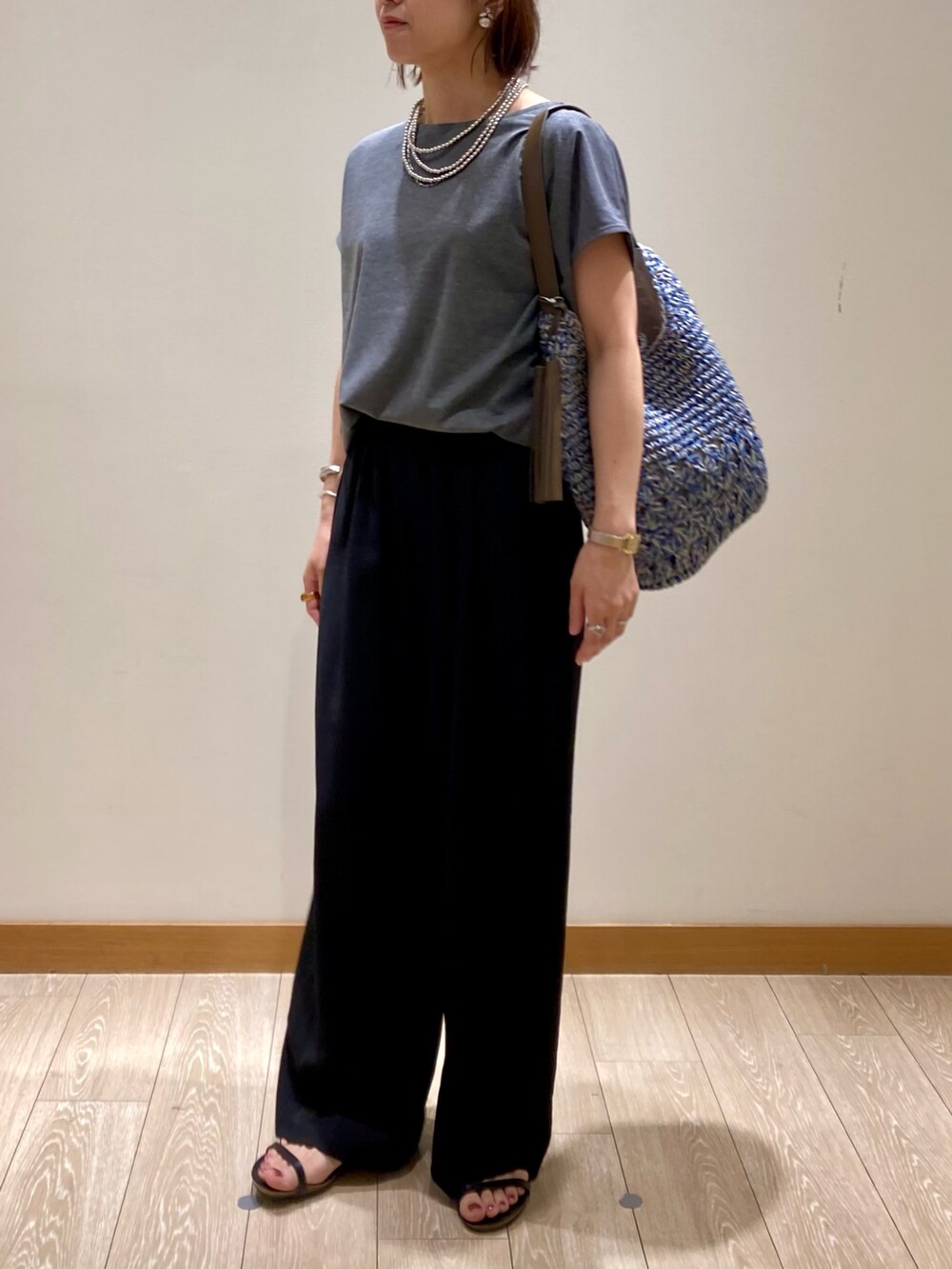 グレー系のTシャツ/カットソー、ブルー系のかごバッグ、ブラック系のその他パンツを着用したレディースの夏コーディネートの7枚目の写真