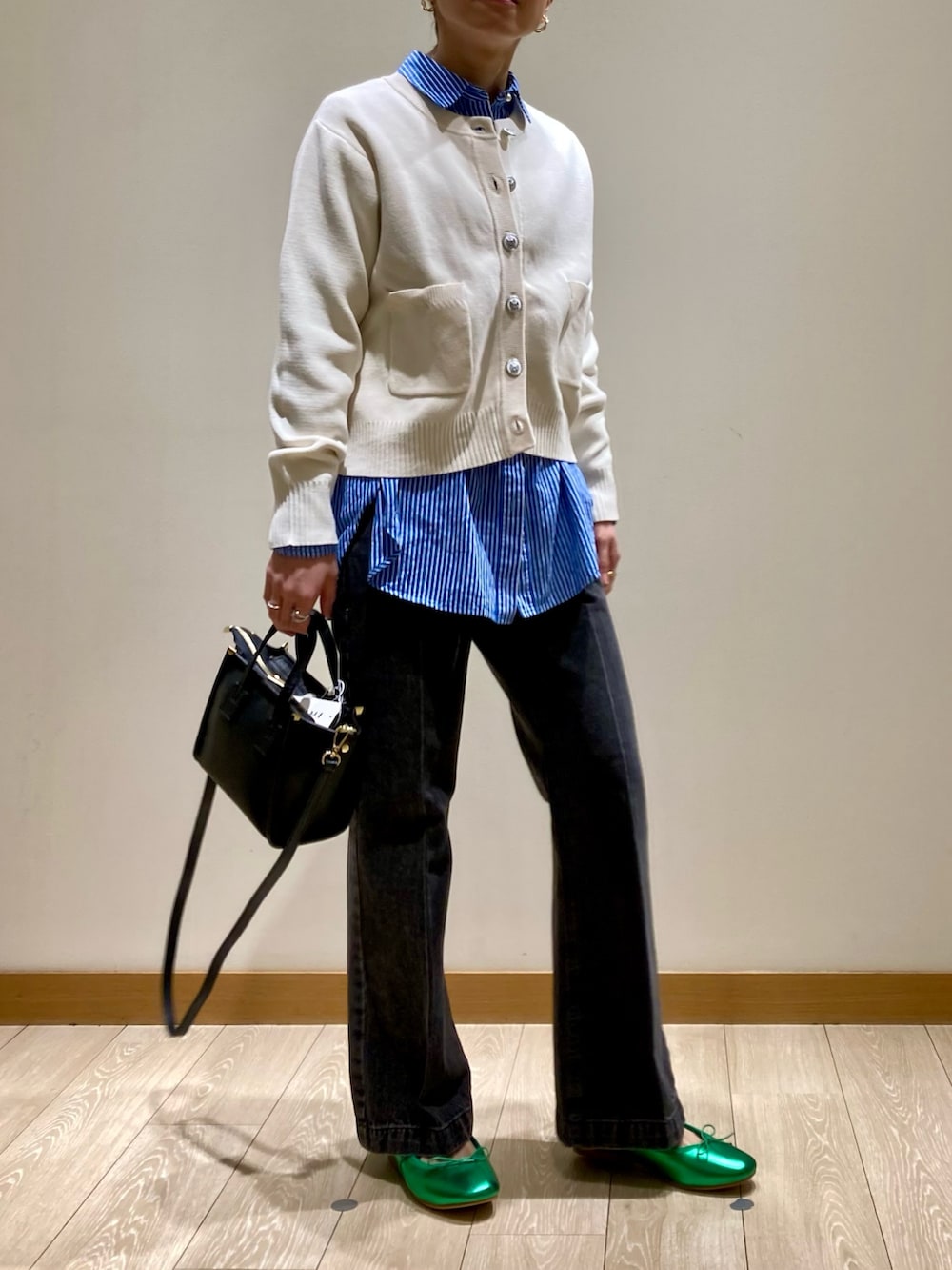 グリーン系のバレエシューズ、ブラック系のトートバッグ、ブラック系のデニムパンツを着用したレディースの冬コーディネートの2枚目の写真