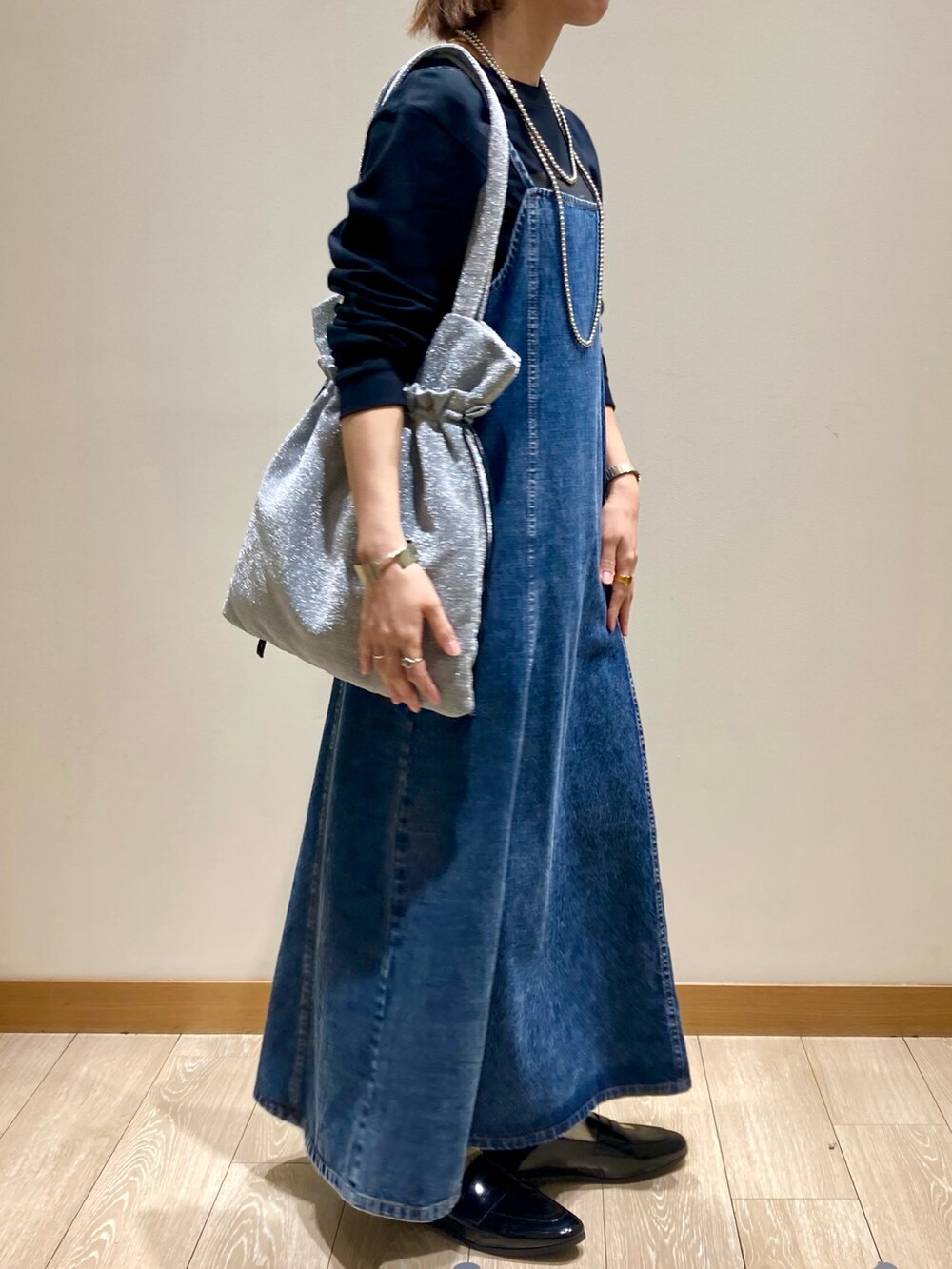 ブラック系のTシャツ/カットソー、ブルー系のワンピース、シルバー系のトートバッグを着用したレディースの秋コーディネートの3枚目の写真