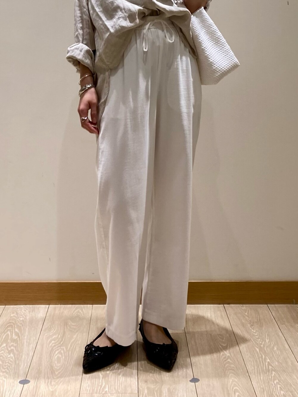 ホワイト系のその他パンツ、ブラック系のバレエシューズ、ベージュ系のシャツ/ブラウスを着用したレディースの春コーディネートの9枚目の写真