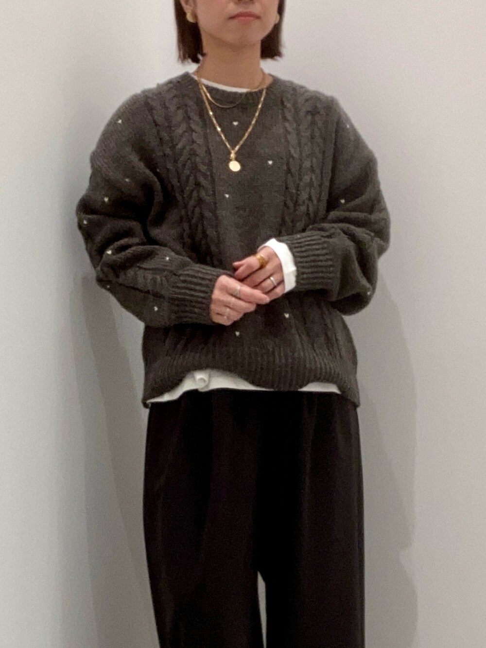 グレー系のニット/セーター、ホワイト系のTシャツ/カットソー、ブラック系のその他パンツを着用したレディースの秋コーディネートの8枚目の写真