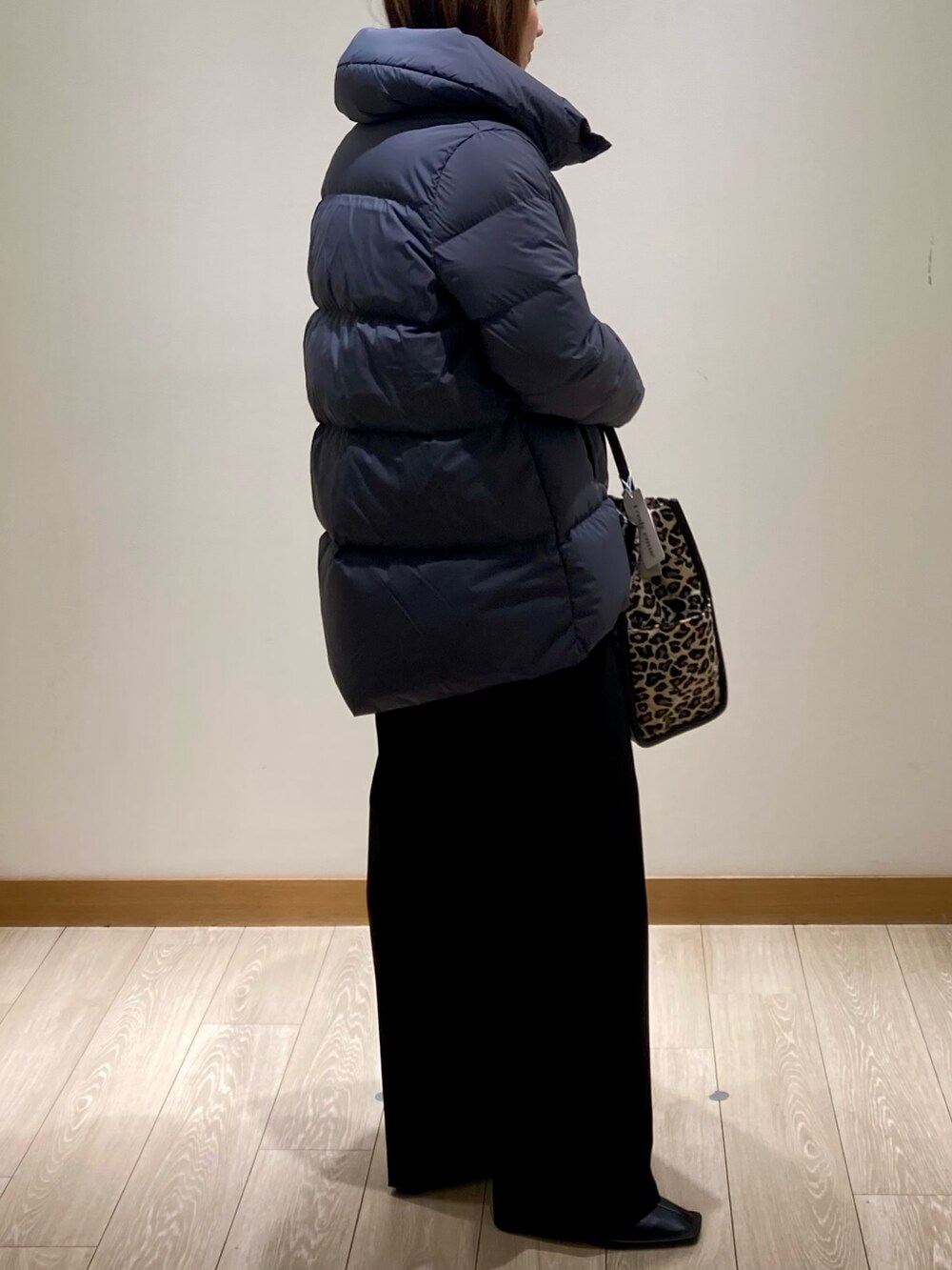 ブラック系のその他パンツ、グレー系のダウンジャケット/コート、イエロー系のニット/セーターを着用したレディースの冬コーディネートの4枚目の写真