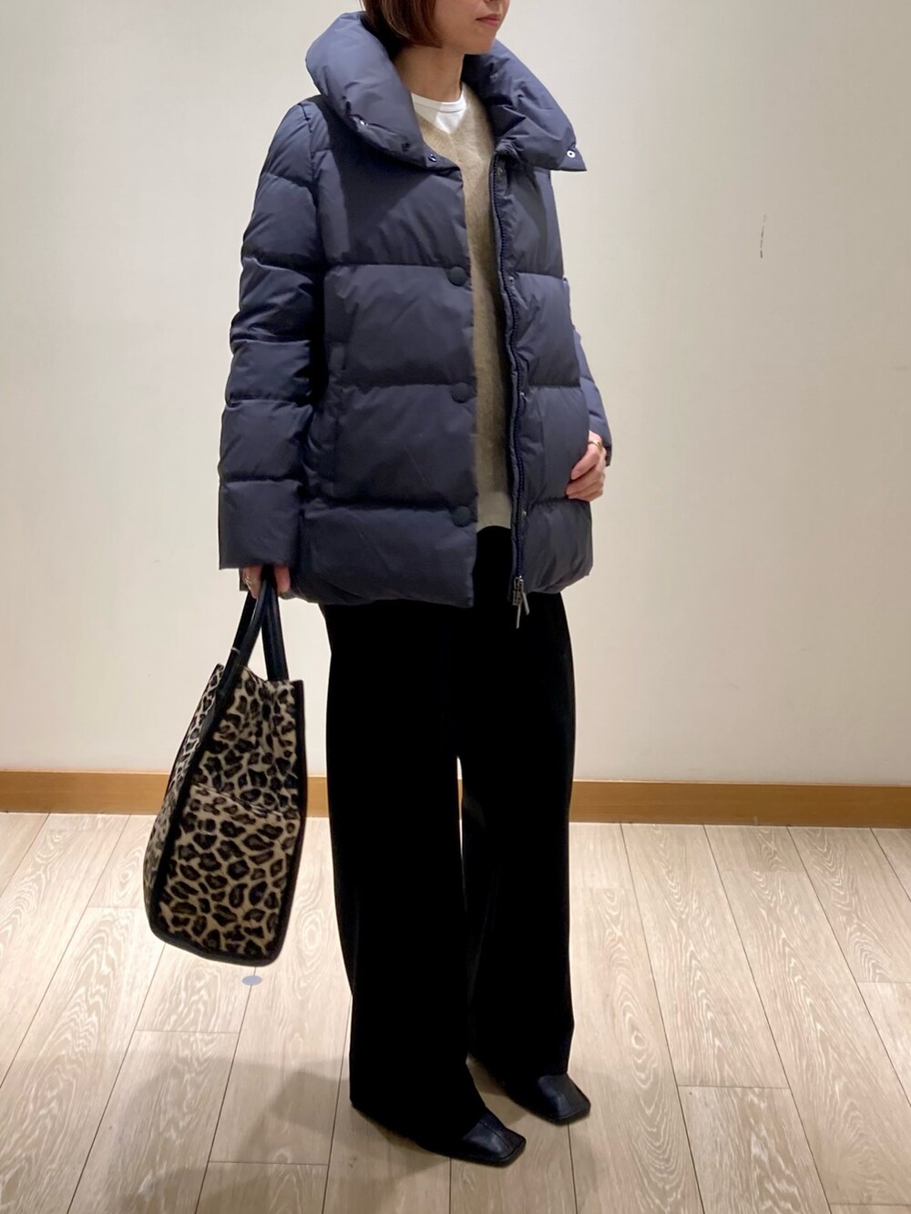 ブラック系のその他パンツ、グレー系のダウンジャケット/コート、イエロー系のニット/セーターを着用したレディースの冬コーディネートの3枚目の写真