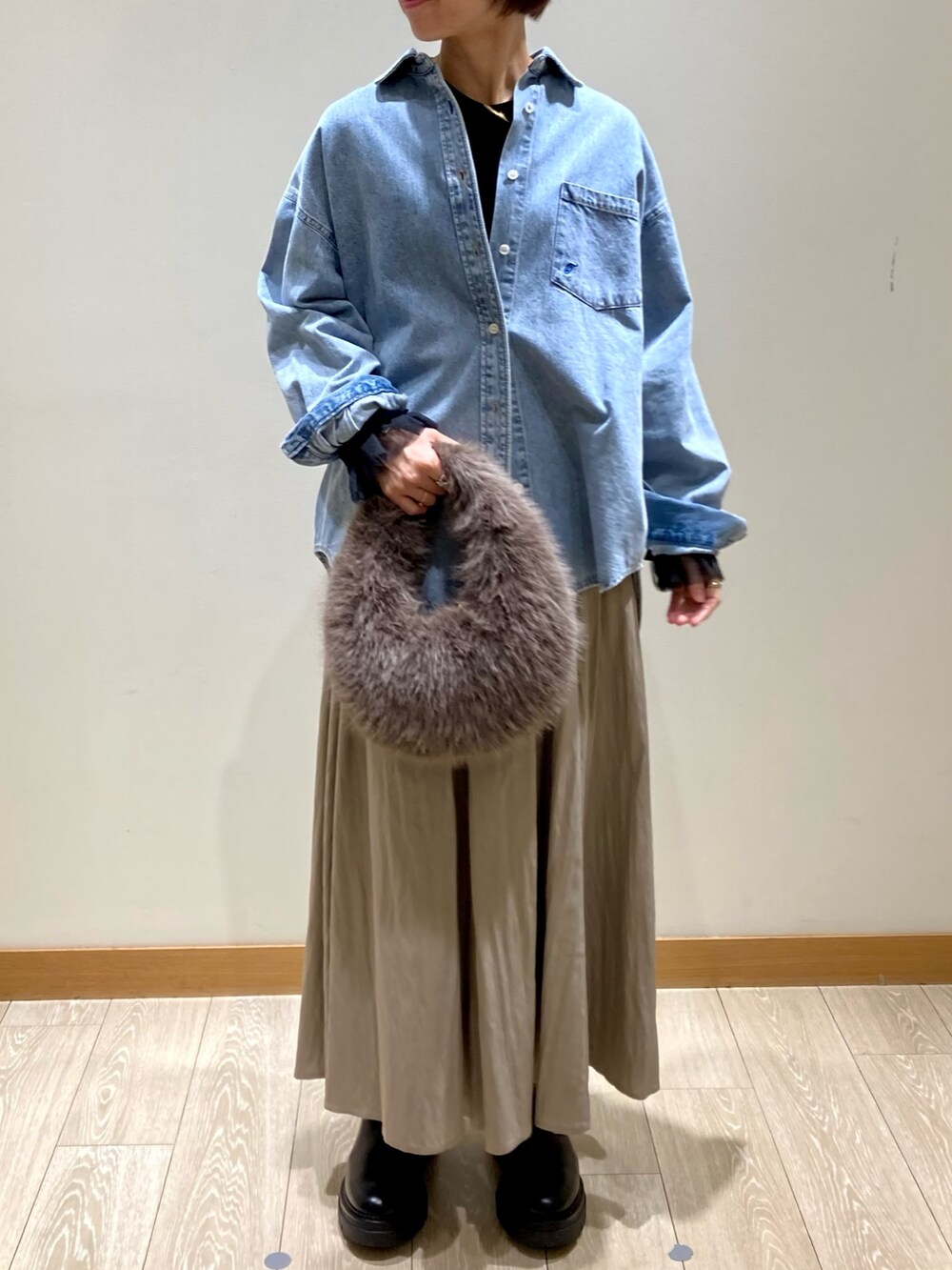 ベージュ系のスカート、ブルー系のシャツ/ブラウス、ブラック系のTシャツ/カットソーを着用したレディースの秋コーディネートの3枚目の写真