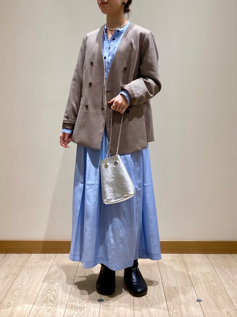 シルバー系のショルダーバッグ、ブルー系のワンピース、ベージュ系のノーカラージャケットを着用したレディースの春コーディネートの7枚目の写真