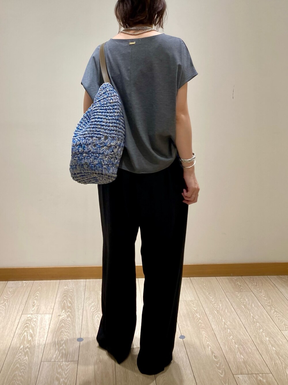 グレー系のTシャツ/カットソー、ブルー系のかごバッグ、ブラック系のその他パンツを着用したレディースの夏コーディネートの5枚目の写真