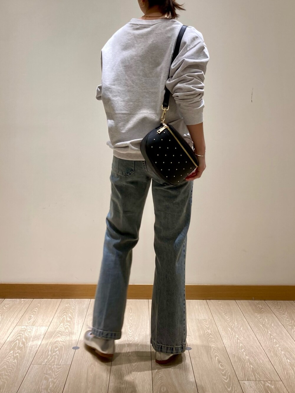 ブルー系のデニムパンツ、ブラック系のショルダーバッグ、シルバー系のバレエシューズを着用したレディースの冬コーディネートの6枚目の写真