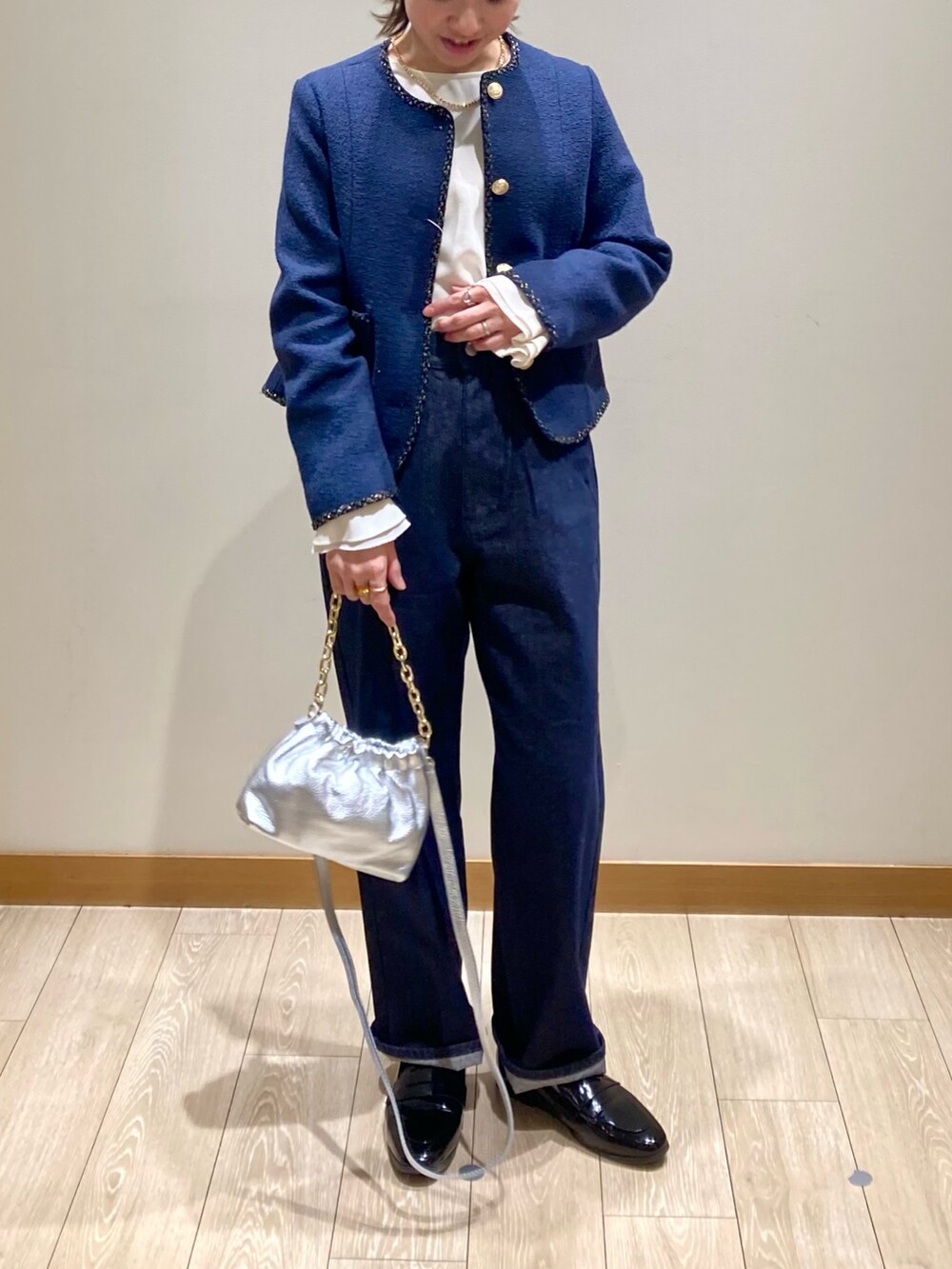 シルバー系のショルダーバッグ、ブルー系のノーカラージャケット、ホワイト系のシャツ/ブラウスを着用したレディースの春コーディネートの2枚目の写真