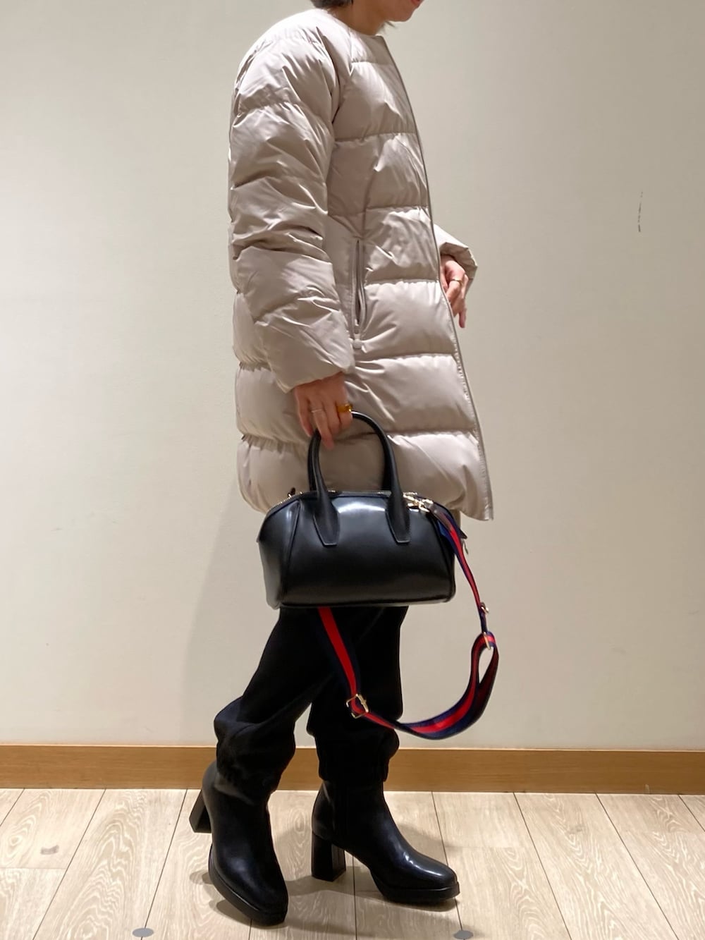 ベージュ系のダウンジャケット/コート、ブラック系のカーゴパンツ、ブラック系のブーツを着用したレディースの冬コーディネートの3枚目の写真