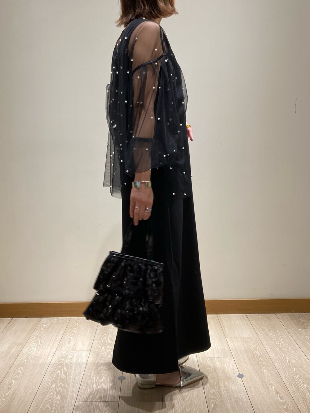 ブラック系のワンピース、ブラック系のTシャツ/カットソー、ブラック系のハンドバッグを着用したレディースの秋コーディネートの3枚目の写真