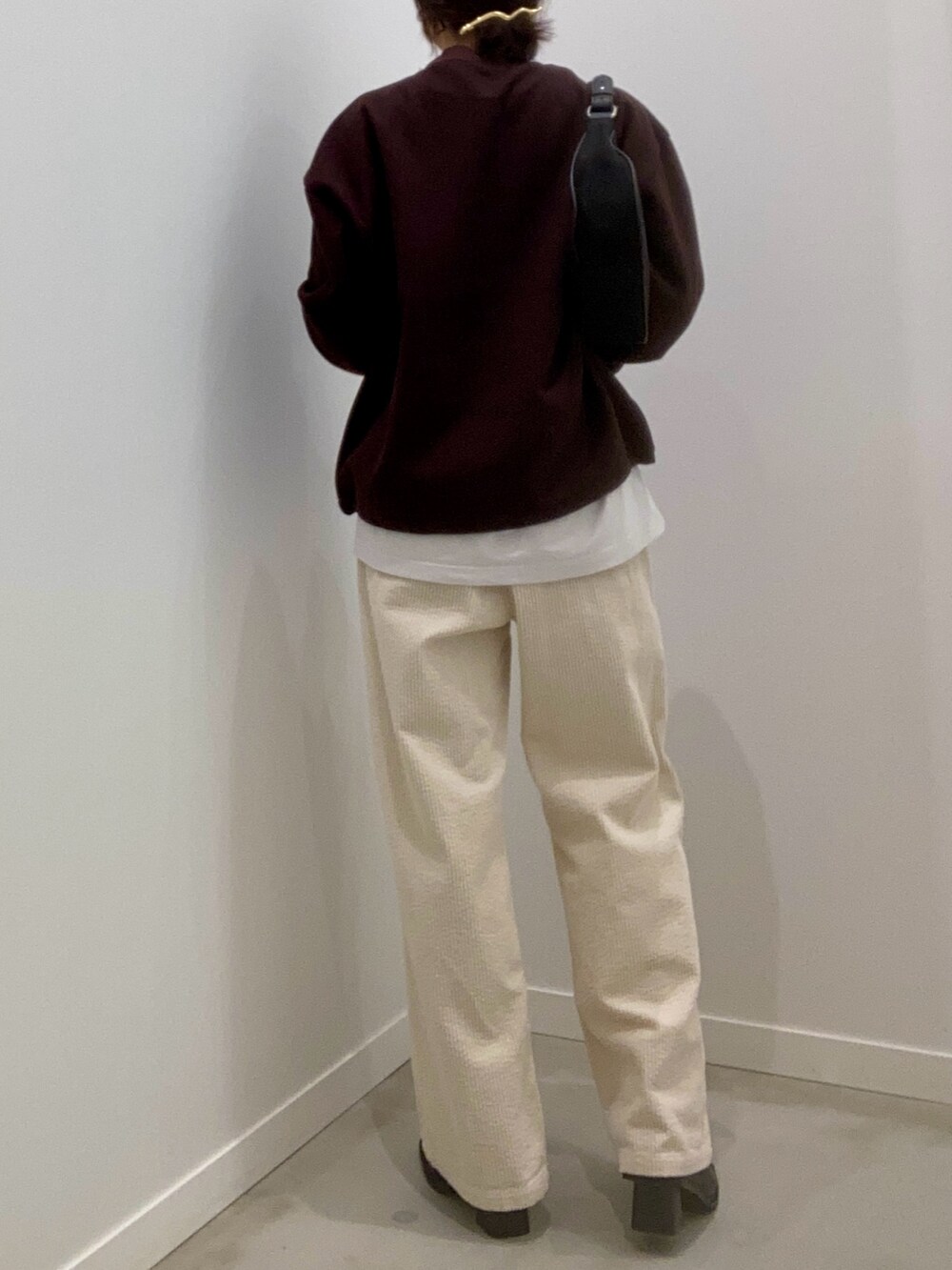 ブラウン系のスウェット、ホワイト系のその他パンツ、ブラック系のショルダーバッグを着用したレディースの冬コーディネートの6枚目の写真
