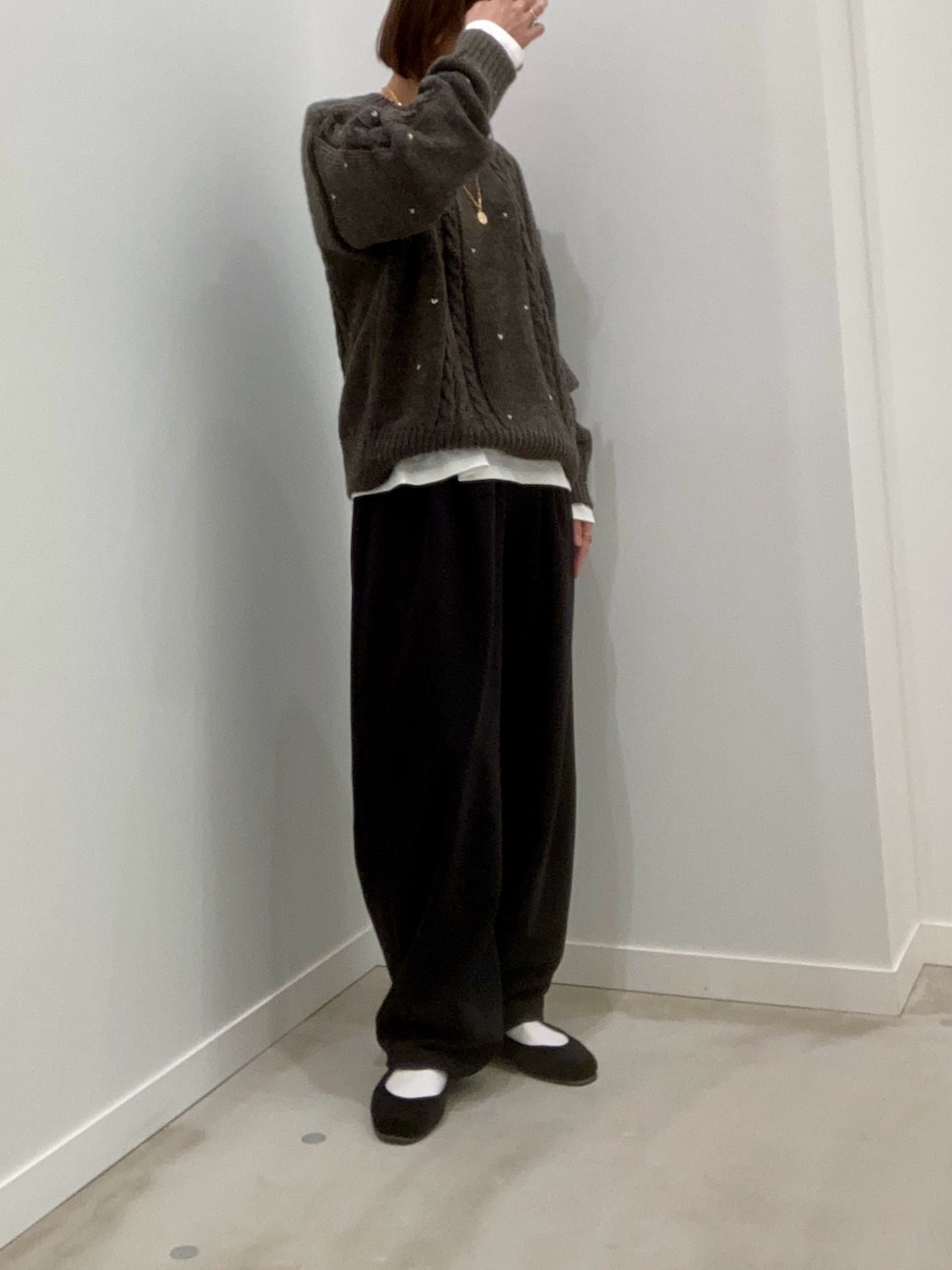 グレー系のニット/セーター、ホワイト系のTシャツ/カットソー、ブラック系のその他パンツを着用したレディースの秋コーディネートの3枚目の写真