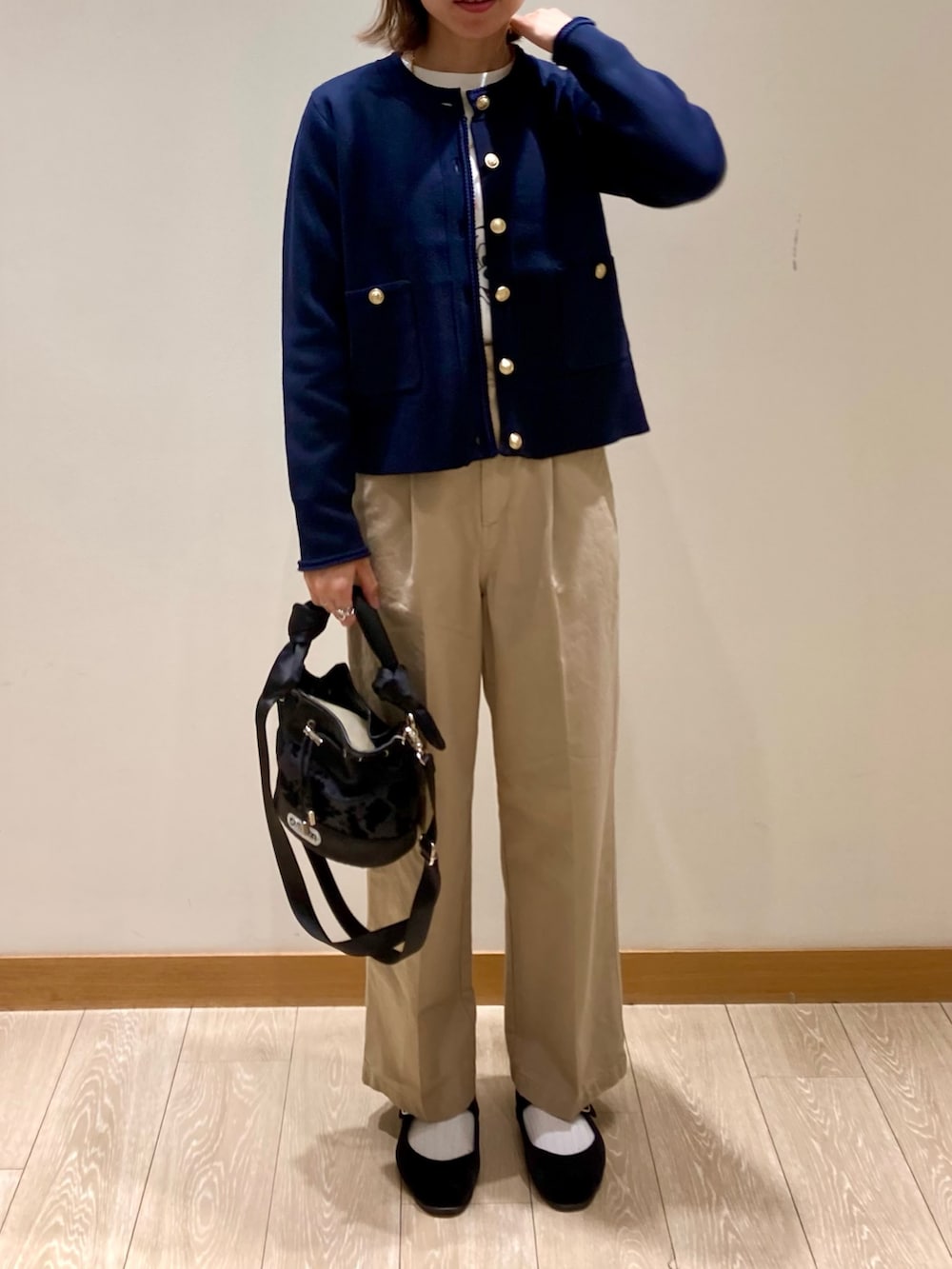 ブラック系のショルダーバッグ、ブルー系のカーディガン/ボレロ、ホワイト系のTシャツ/カットソーを着用したレディースの秋コーディネートの2枚目の写真