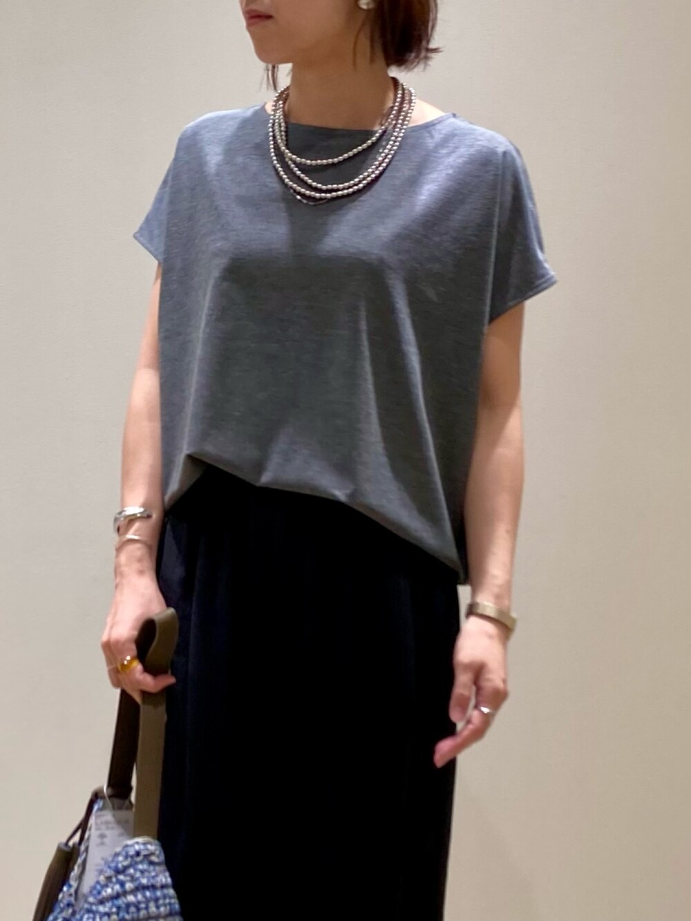 グレー系のTシャツ/カットソー、ブルー系のかごバッグ、ブラック系のその他パンツを着用したレディースの夏コーディネートの9枚目の写真