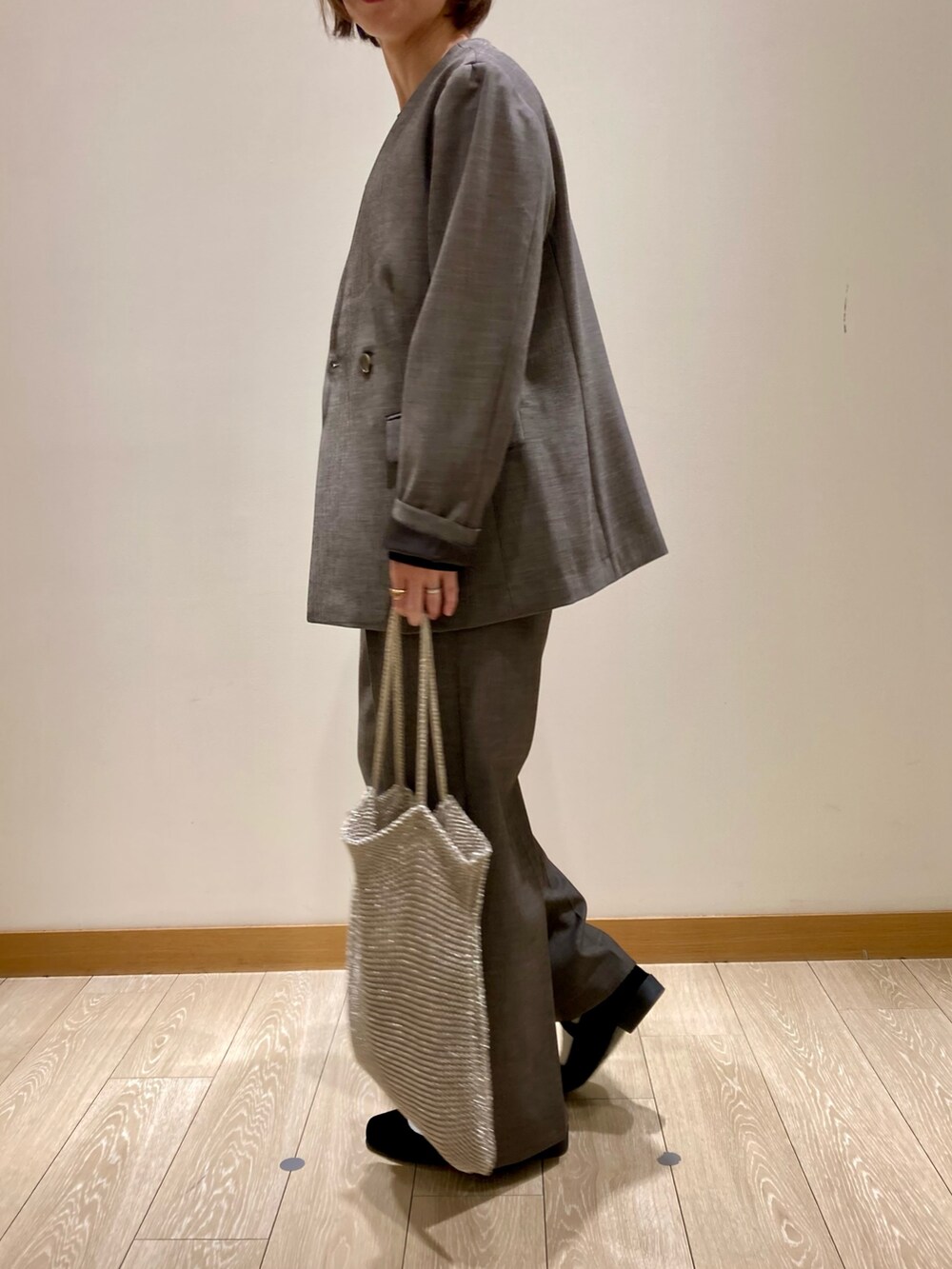 グレー系のノーカラージャケット、グレー系のスラックス、ブラック系のTシャツ/カットソーを着用したレディースの秋コーディネートの5枚目の写真