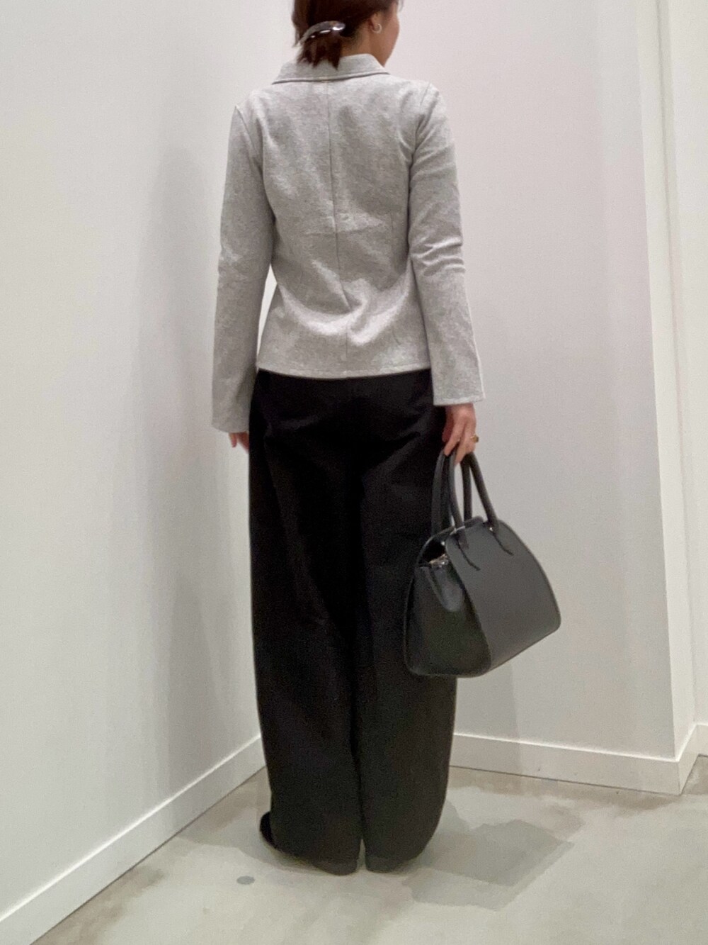 グレー系のカーディガン/ボレロ、グレー系のTシャツ/カットソー、ブラック系のチノパンツを着用したレディースの冬コーディネートの2枚目の写真