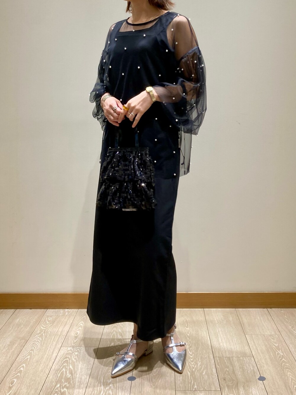 ブラック系のワンピース、ブラック系のTシャツ/カットソー、ブラック系のハンドバッグを着用したレディースの秋コーディネートの7枚目の写真