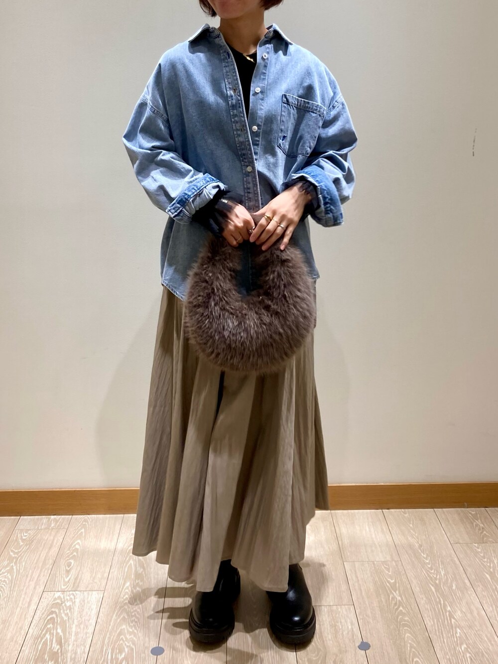 ベージュ系のスカート、ブルー系のシャツ/ブラウス、ブラック系のTシャツ/カットソーを着用したレディースの秋コーディネートの2枚目の写真