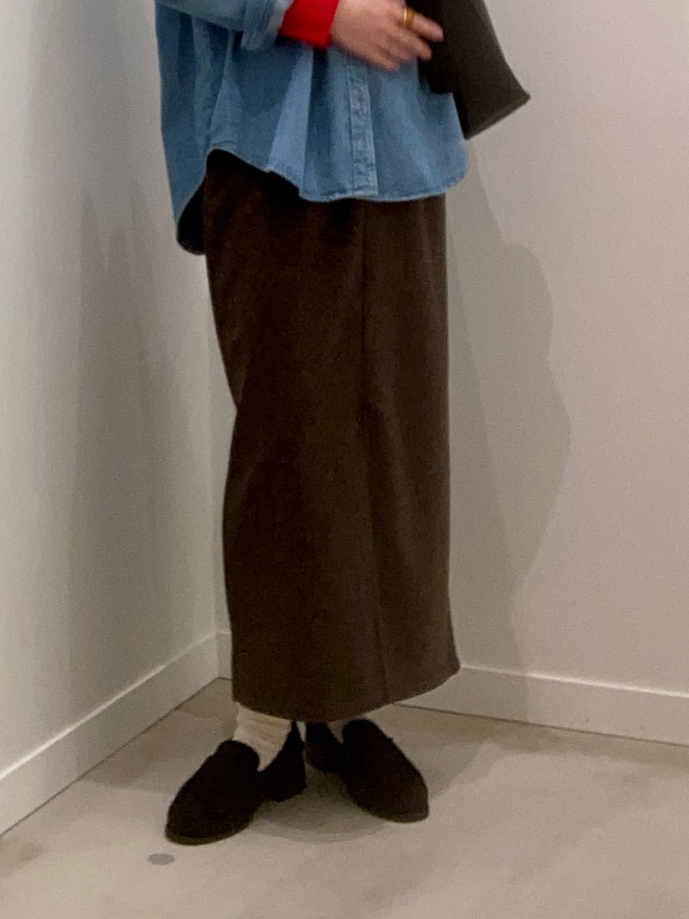 レッド系のニット/セーター、ブルー系のシャツ/ブラウス、ブラウン系のスカートを着用したレディースの冬コーディネートの9枚目の写真