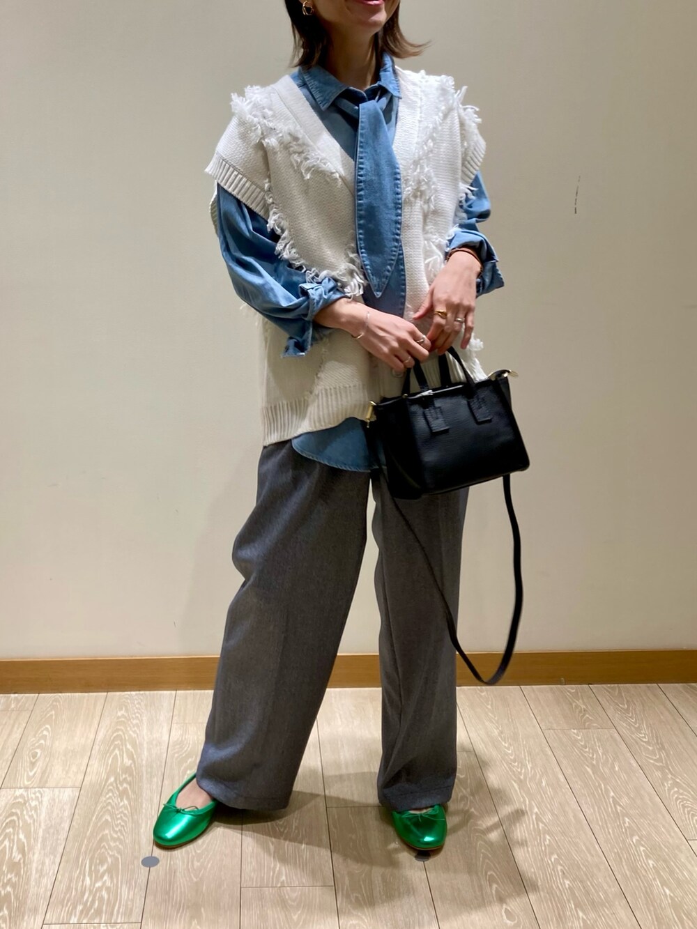 ブラック系のトートバッグ、ブルー系のスラックス、グリーン系のバレエシューズを着用したレディースの冬コーディネートの8枚目の写真