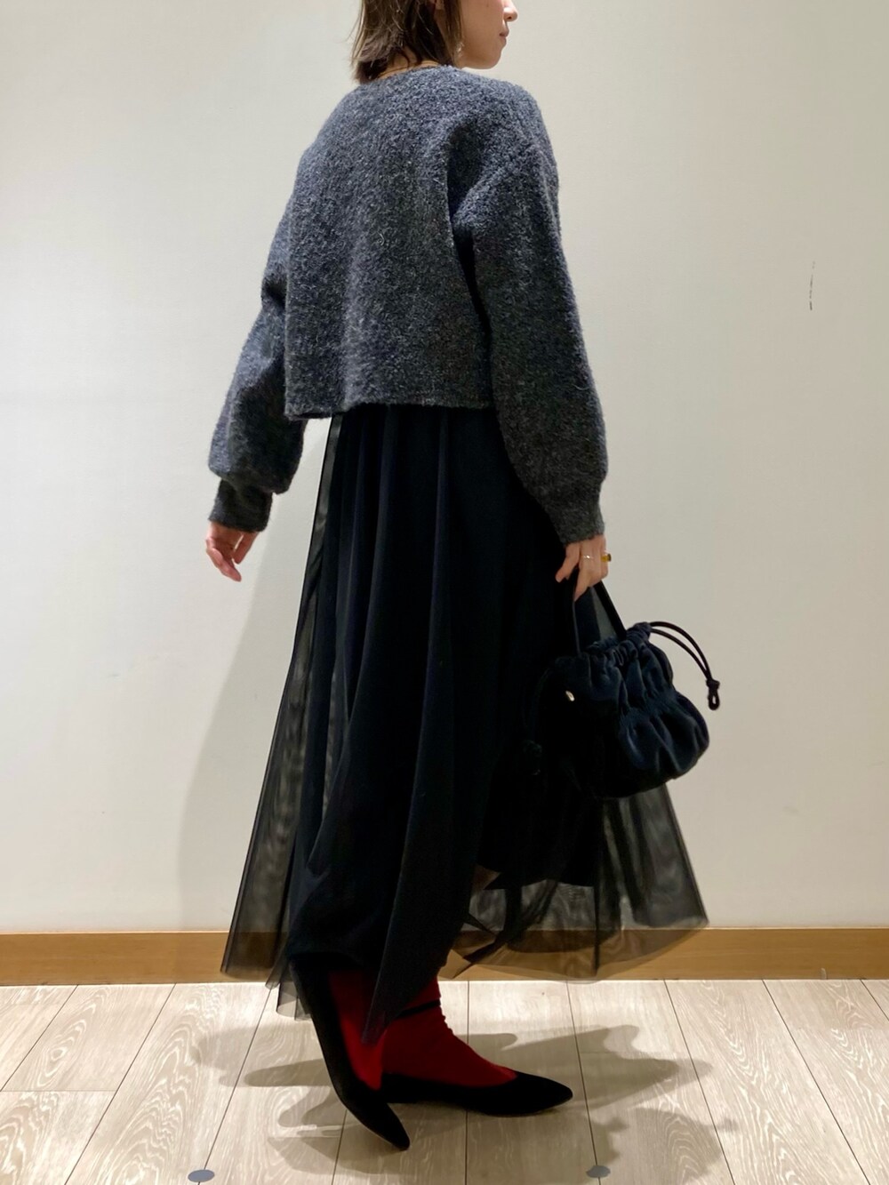 ブラック系のワンピース、ブラック系のショルダーバッグを着用したレディースの冬コーディネートの3枚目の写真