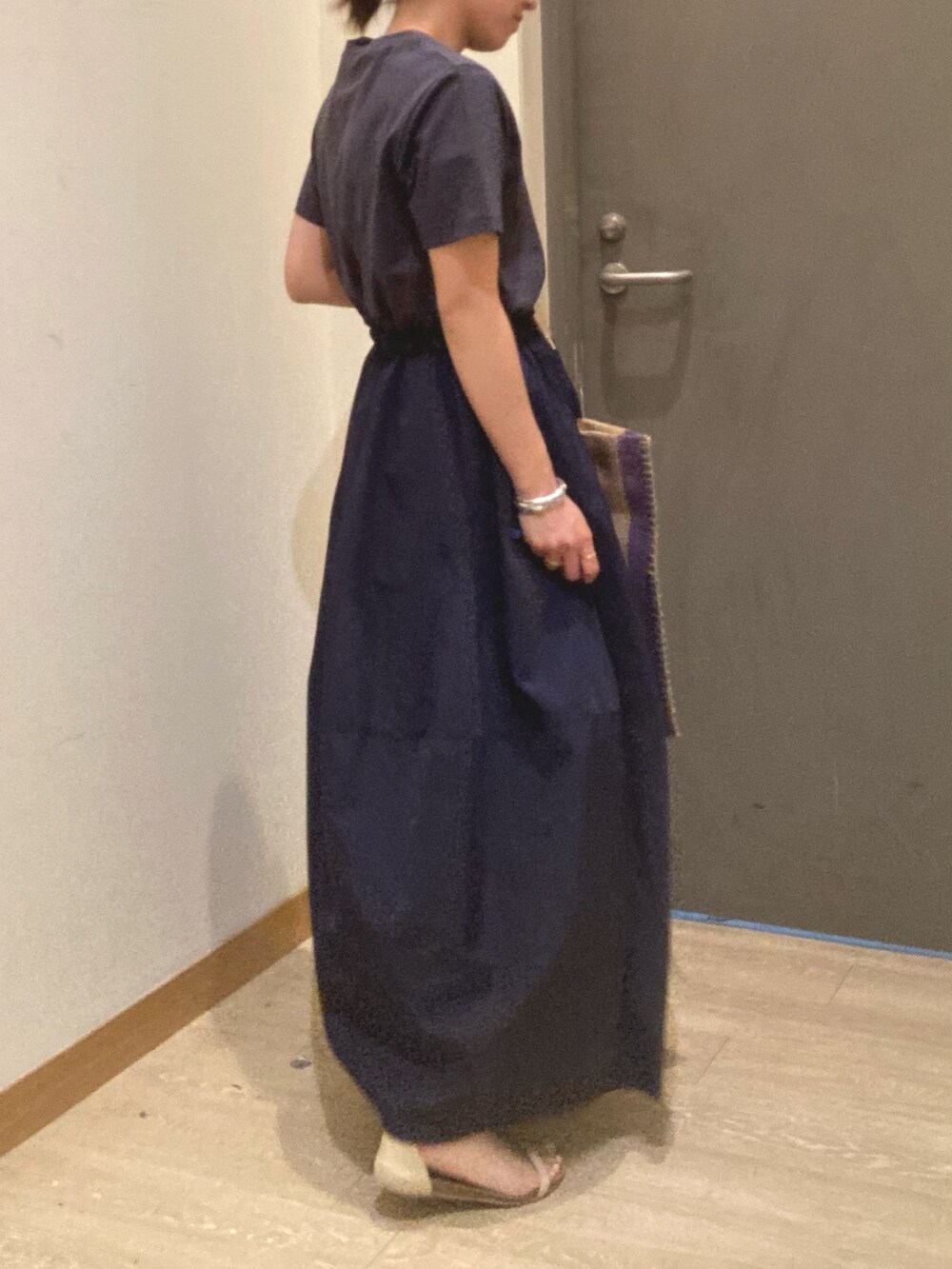 グレー系のワンピース、ブルー系のトートバッグ、ベージュ系のサンダルを着用したレディースの春コーディネートの3枚目の写真