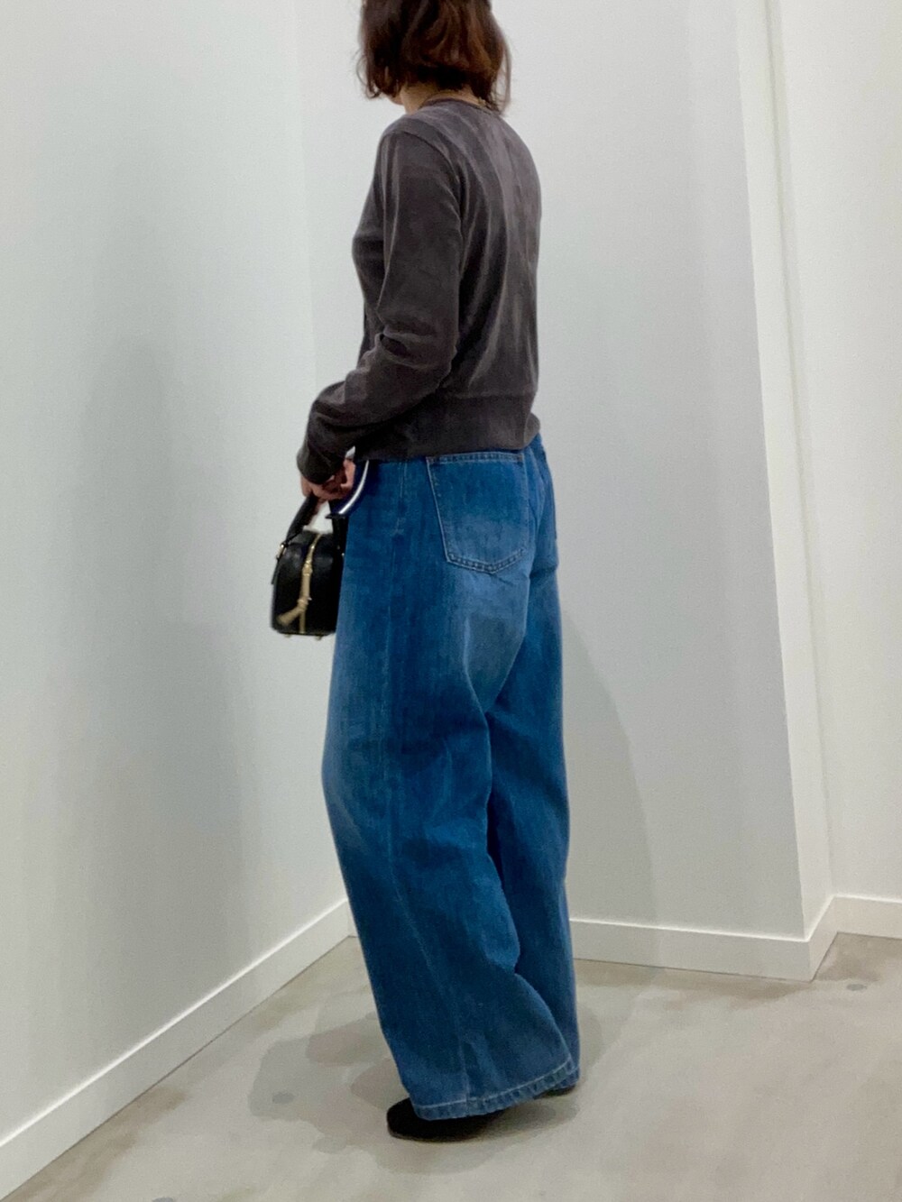 グレー系のカーディガン/ボレロ、ブルー系のデニムパンツ、ブラック系のショルダーバッグを着用したレディースの秋コーディネートの7枚目の写真