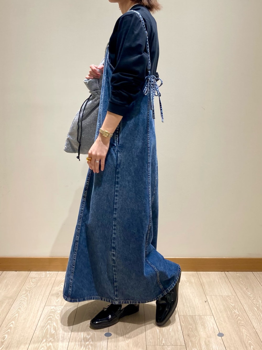 ブラック系のTシャツ/カットソー、ブルー系のワンピース、シルバー系のトートバッグを着用したレディースの秋コーディネートの7枚目の写真