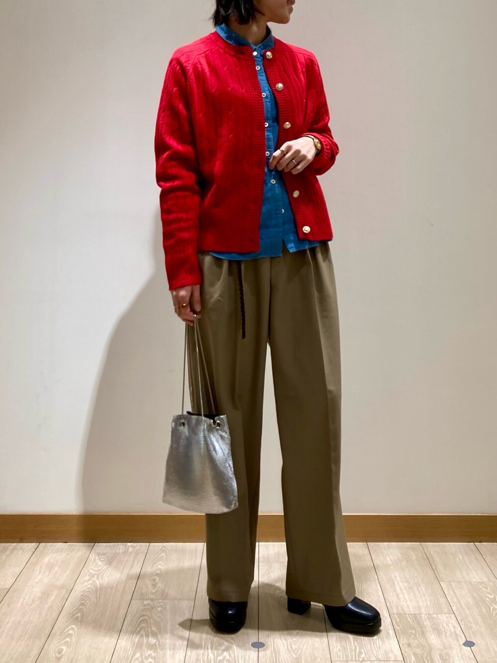 レッド系のカーディガン/ボレロ、ブラック系のブーツ、ベージュ系のスラックスを着用したレディースの冬コーディネートの4枚目の写真