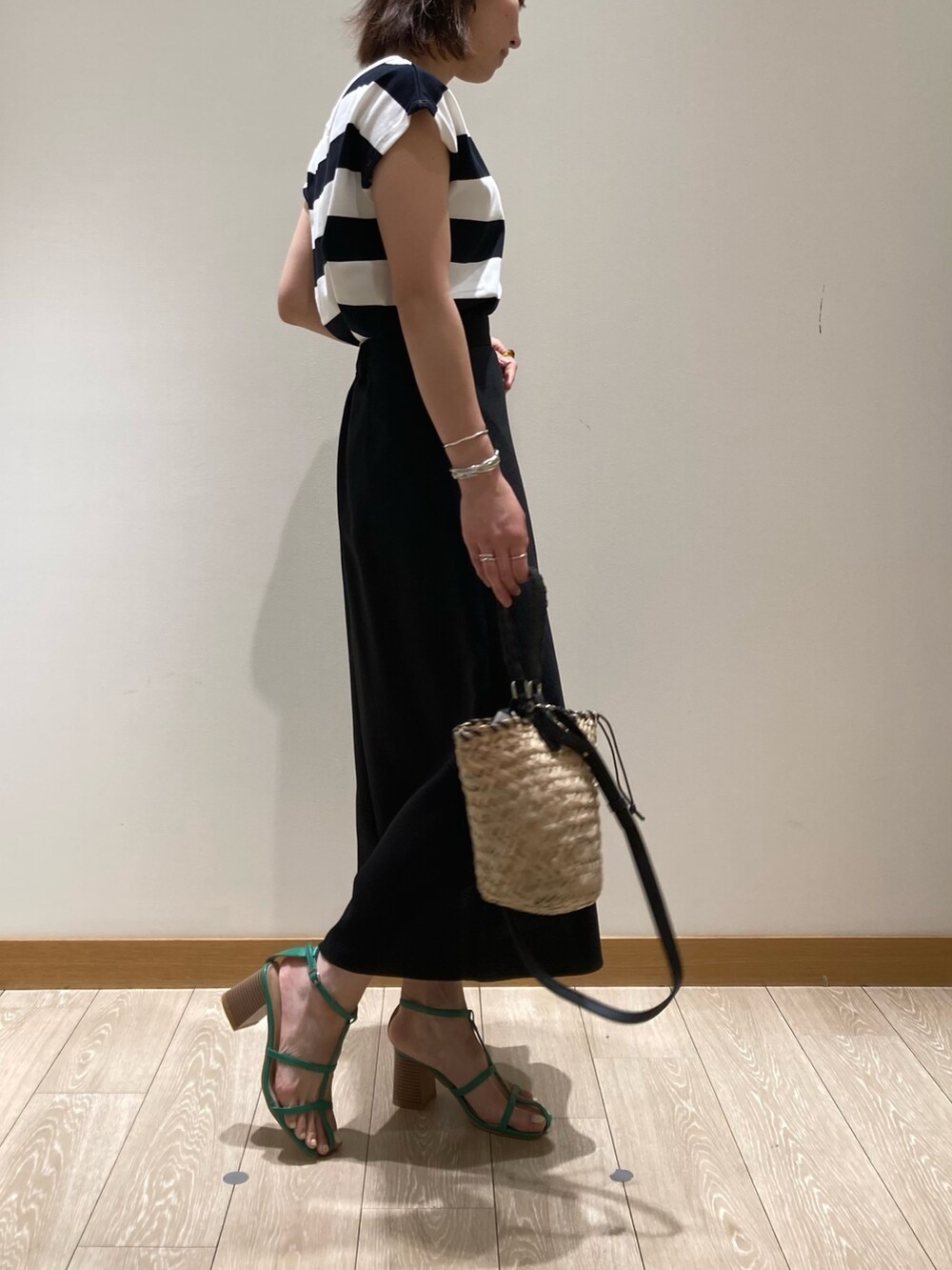 ブラック系のかごバッグ、ブラック系のスカート、ブラック系のTシャツ/カットソーを着用したレディースの春コーディネートの2枚目の写真