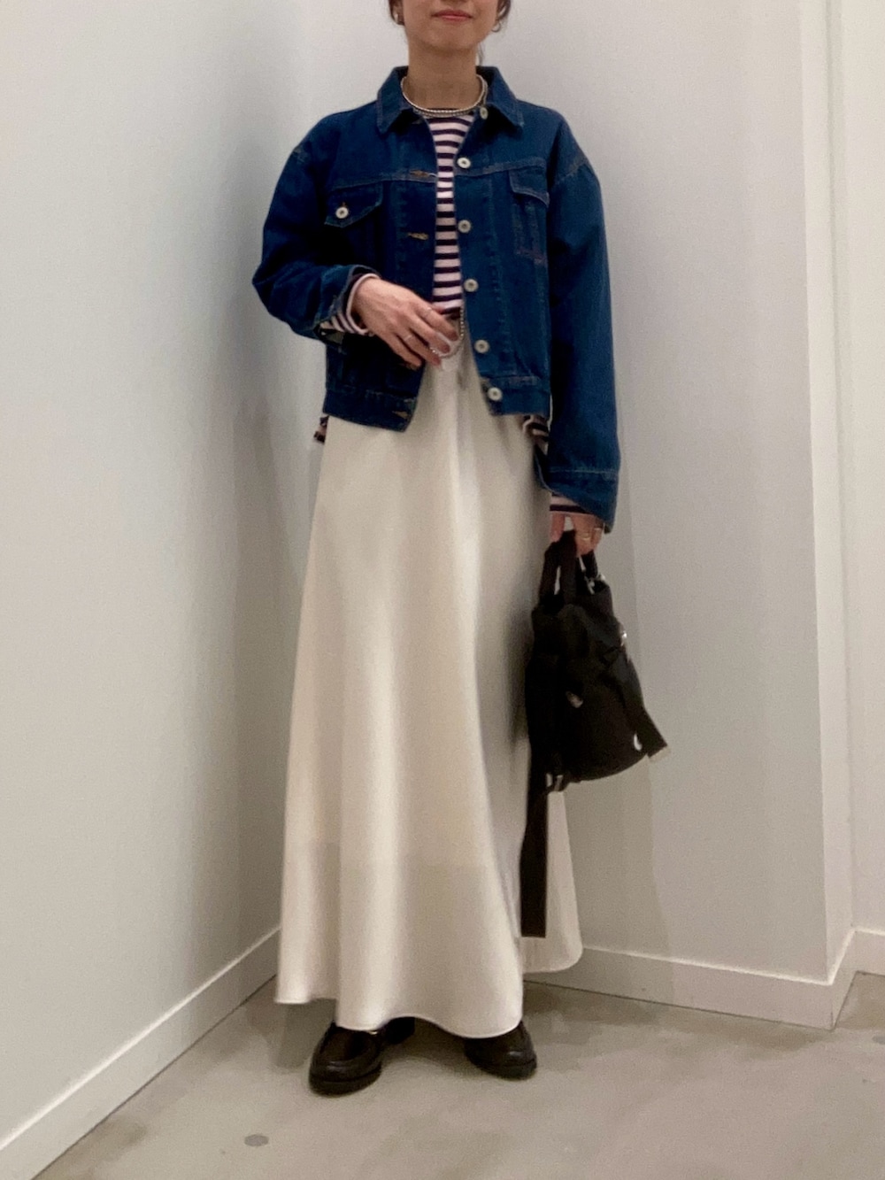 ブルー系のデニムジャケット、ホワイト系のスカート、ブラック系のその他シューズを着用したレディースの冬コーディネートの8枚目の写真