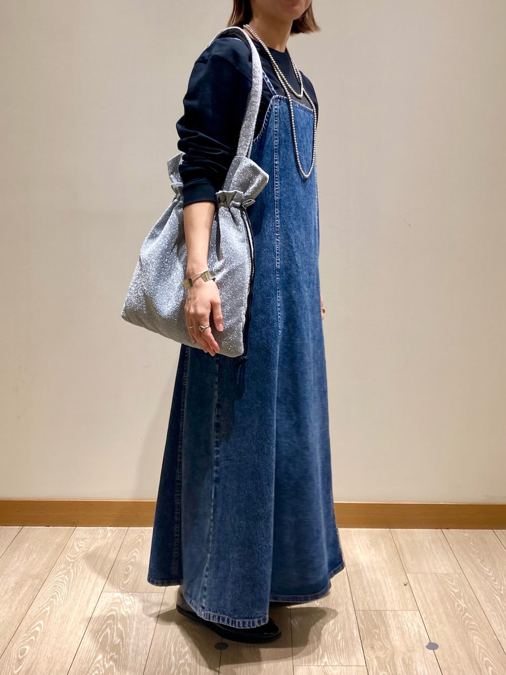 ブラック系のTシャツ/カットソー、ブルー系のワンピース、シルバー系のトートバッグを着用したレディースの秋コーディネートの2枚目の写真